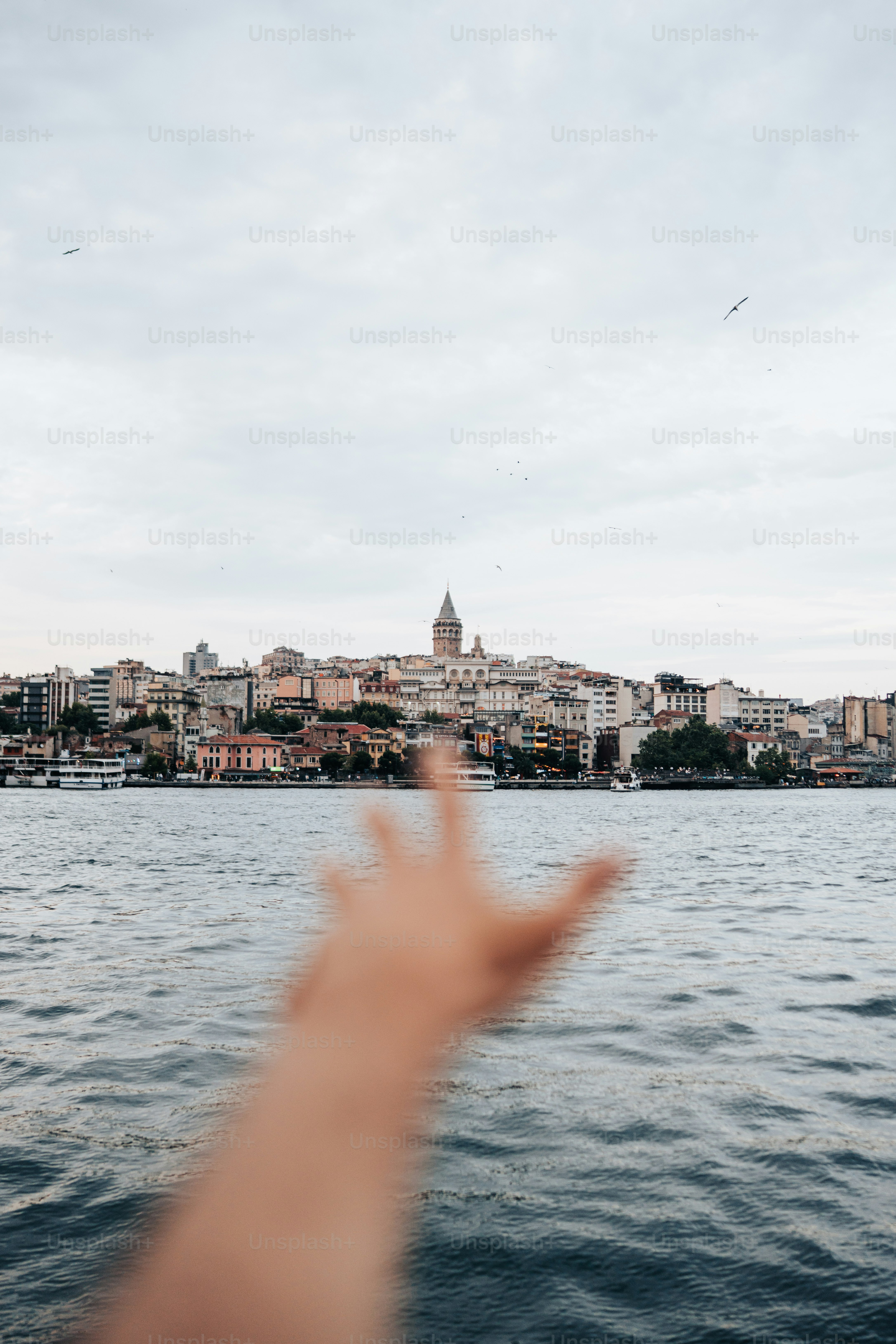 Hand points toward istanbul's cityscape and water.