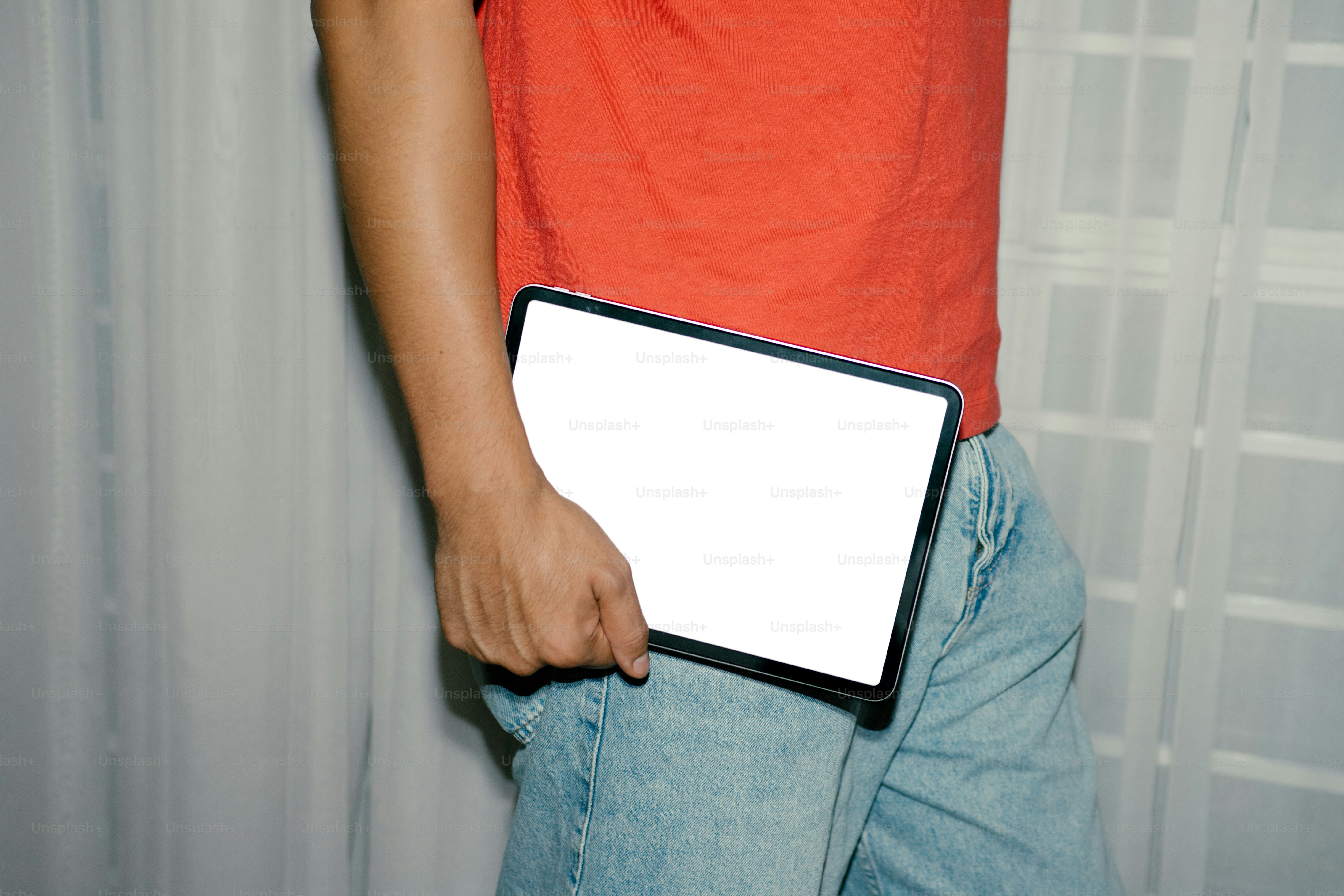 A person holds a tablet with a blank screen.