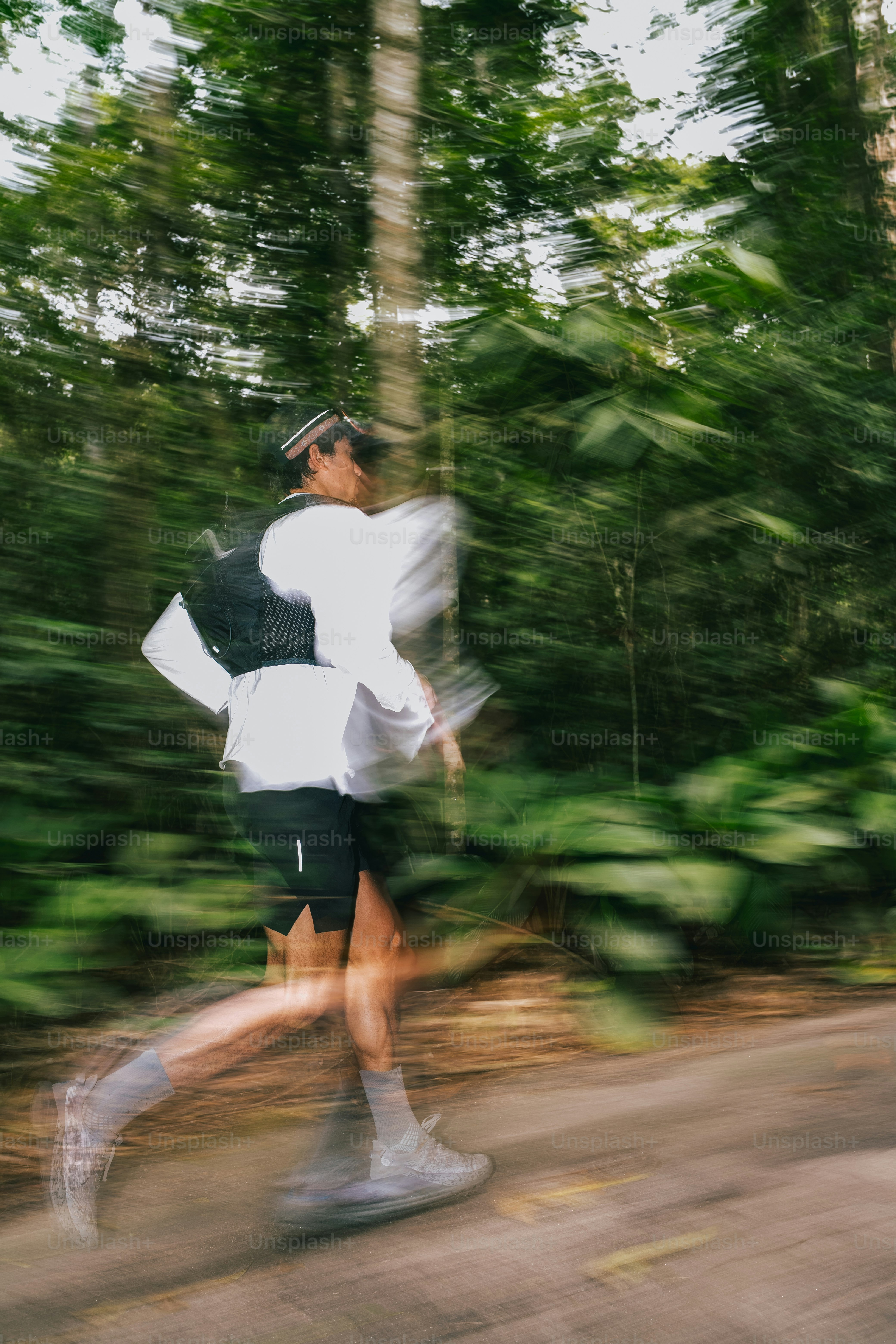 A runner is seen jogging through the forest. photo – Sport Image on ...