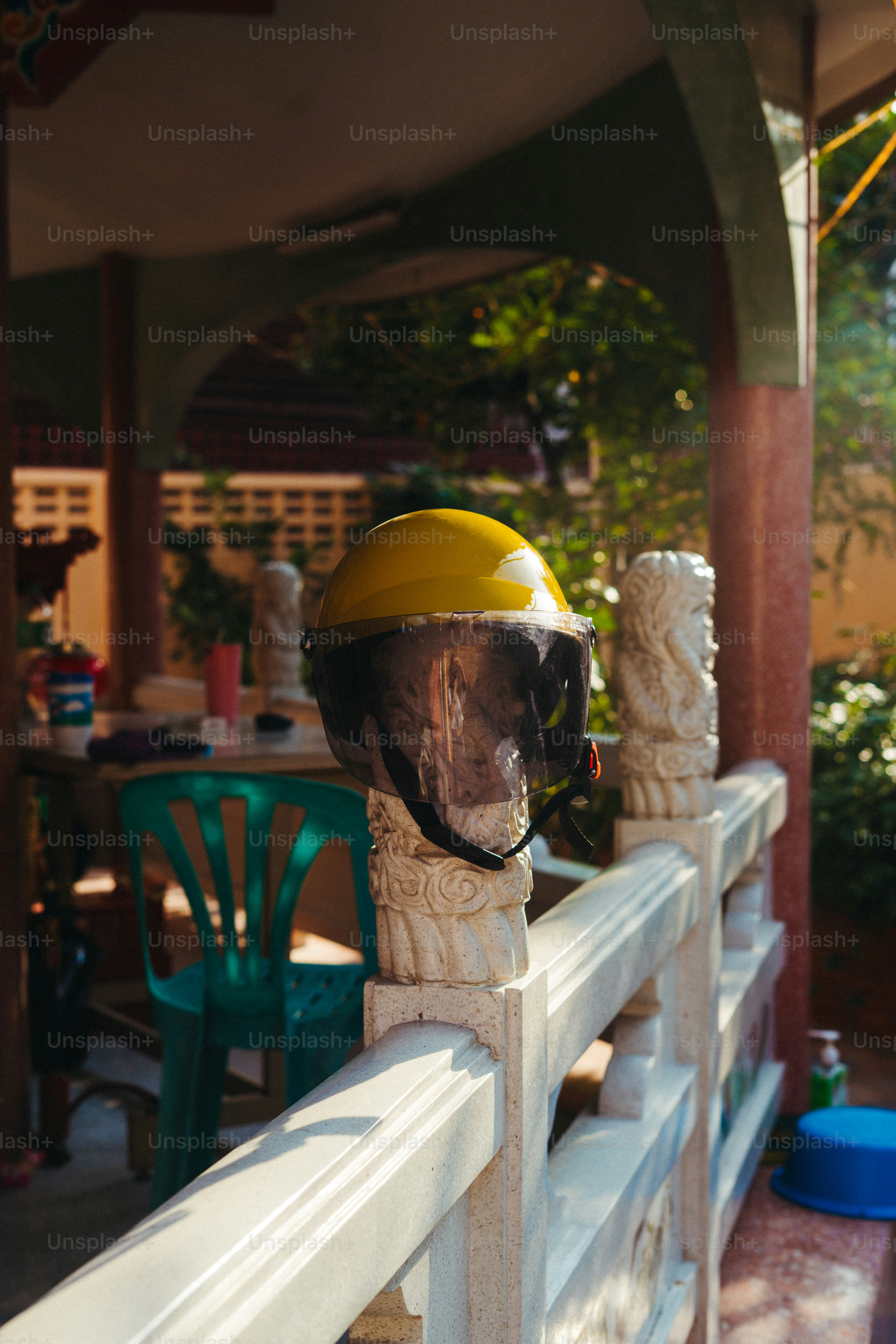 A yellow helmet rests on a stone railing.