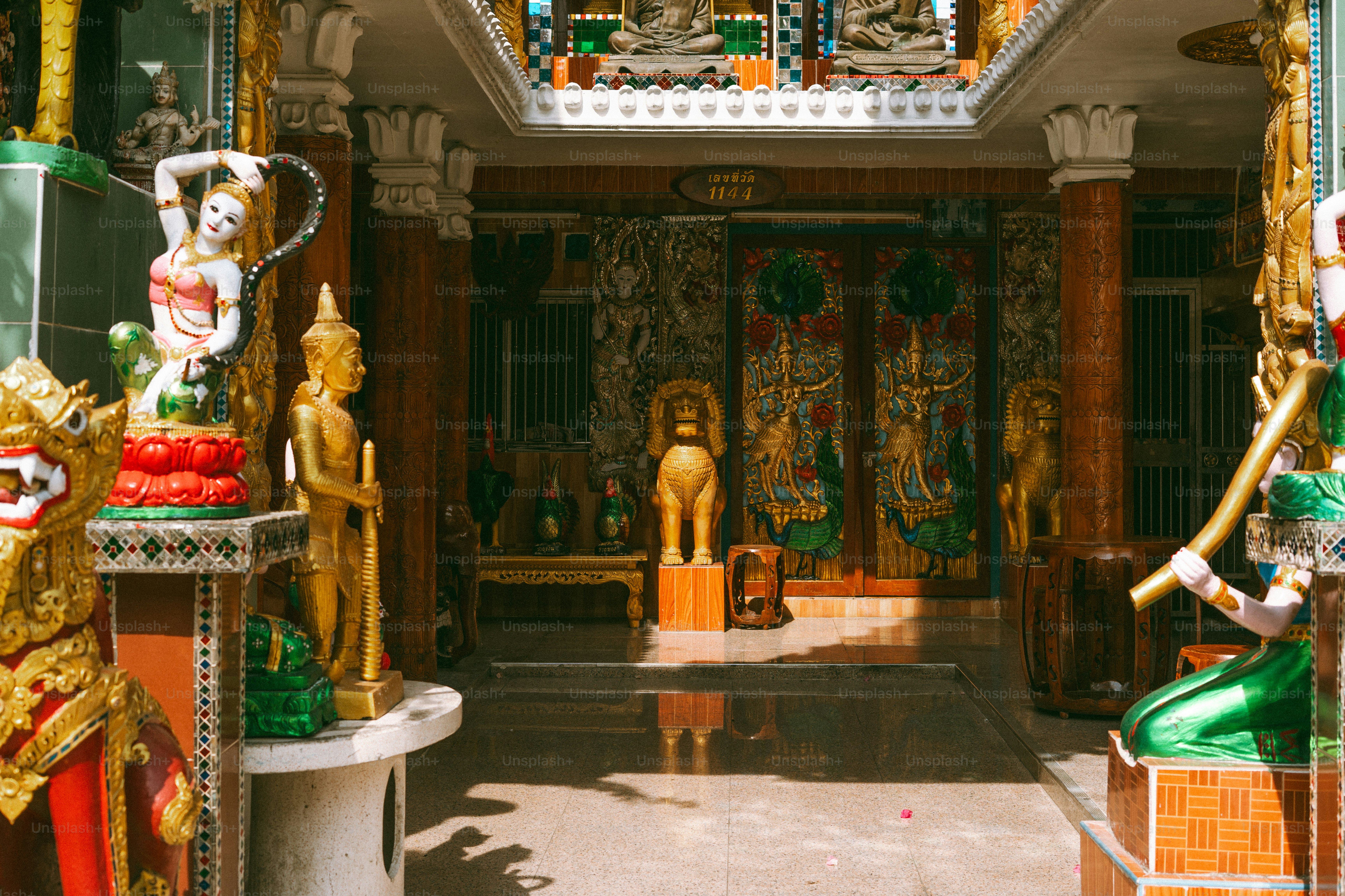 A golden temple interior is filled with statues.