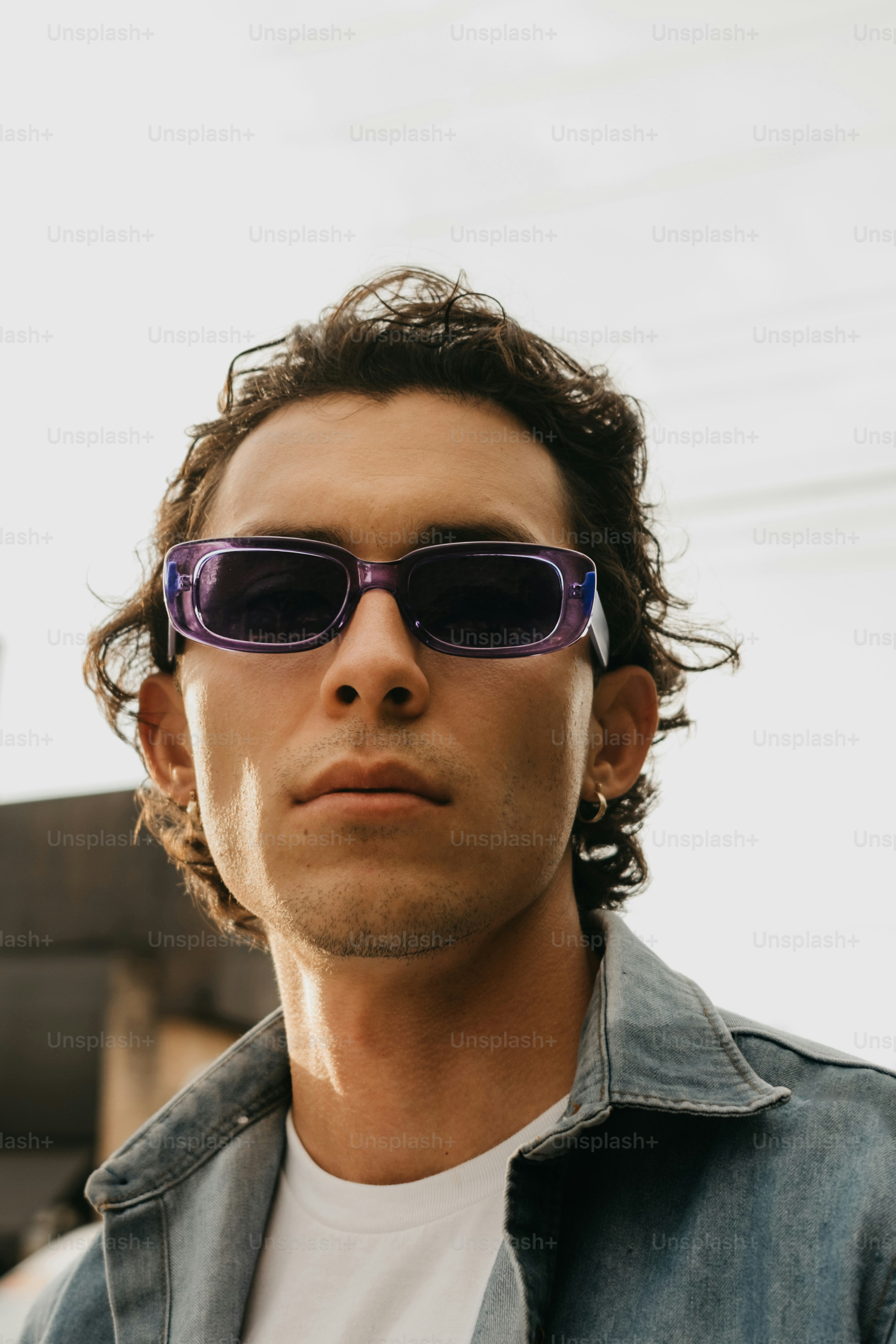 L'uomo indossa occhiali da sole viola all'esterno.