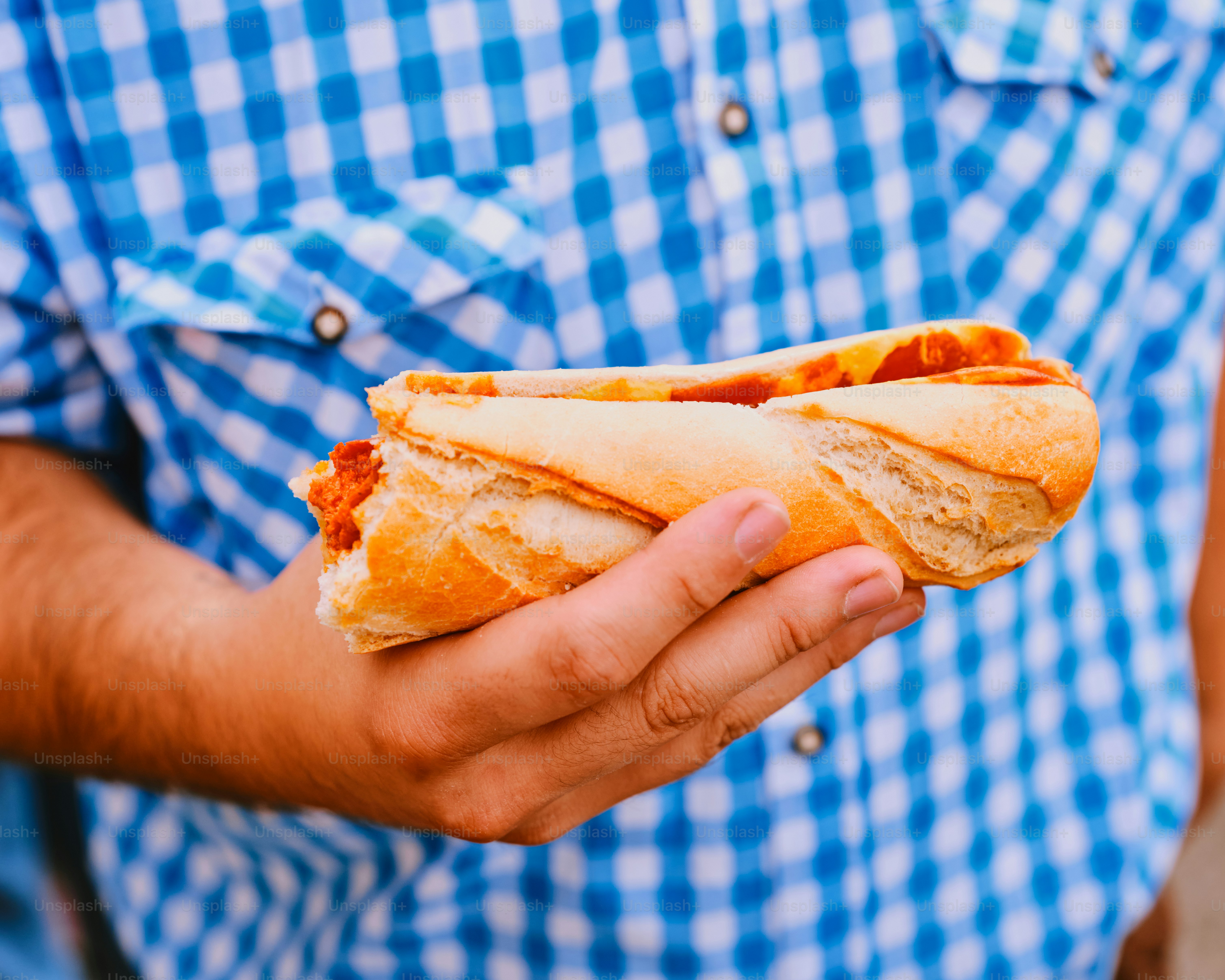 A person holds a delicious hot dog.