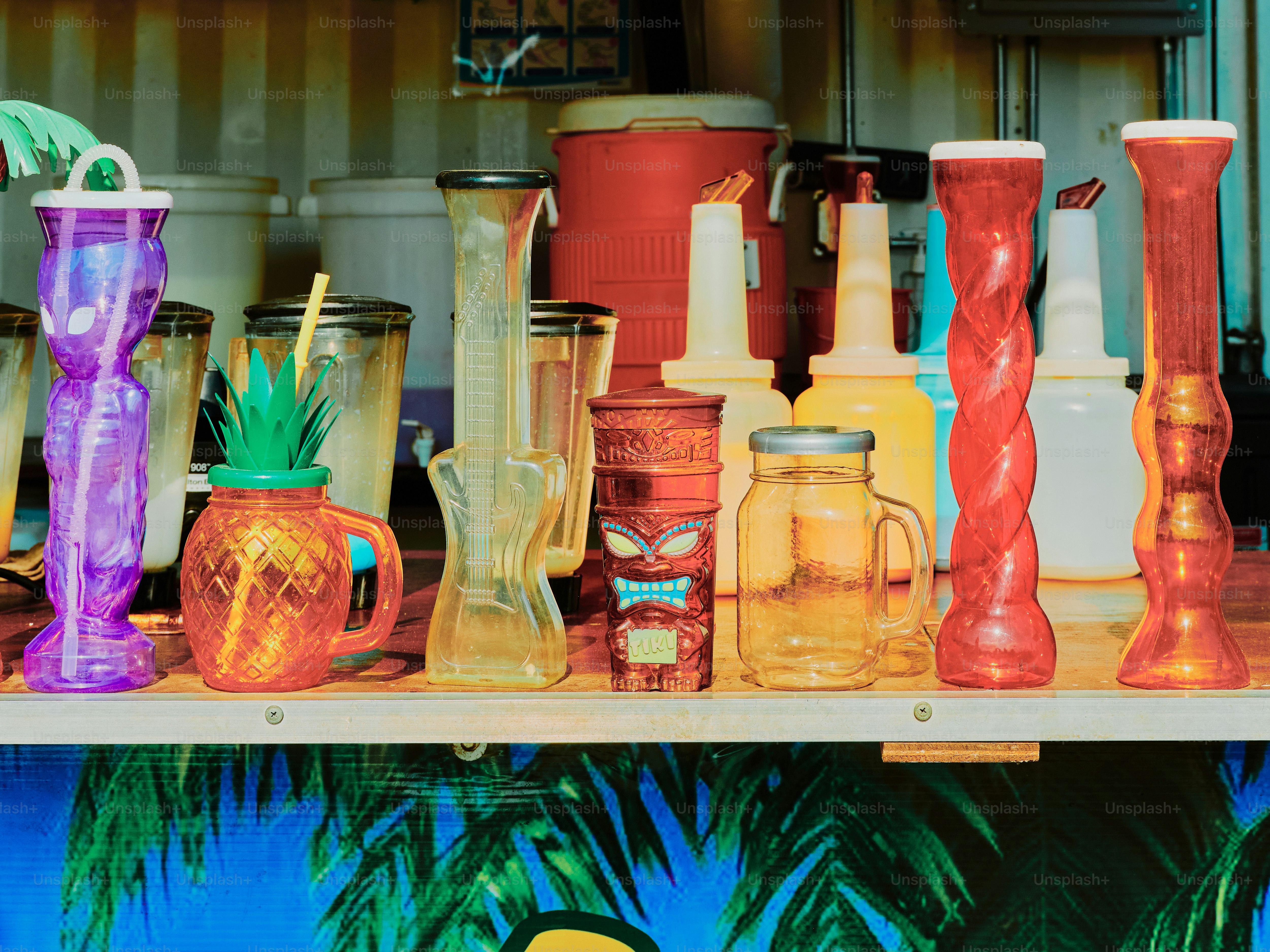 Colorful cocktail glasses line a bar shelf.