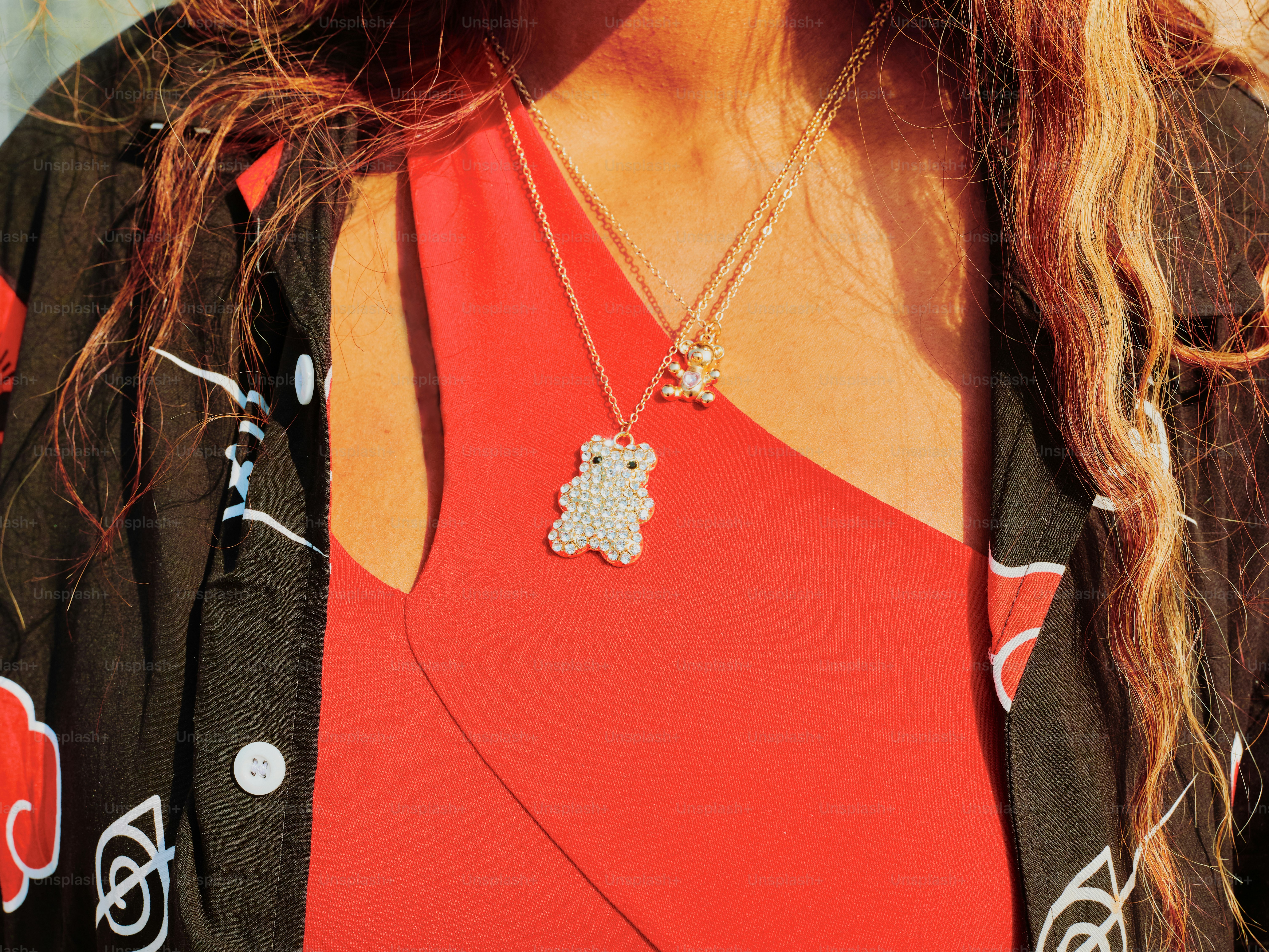 A woman is wearing a red dress with jewelry.