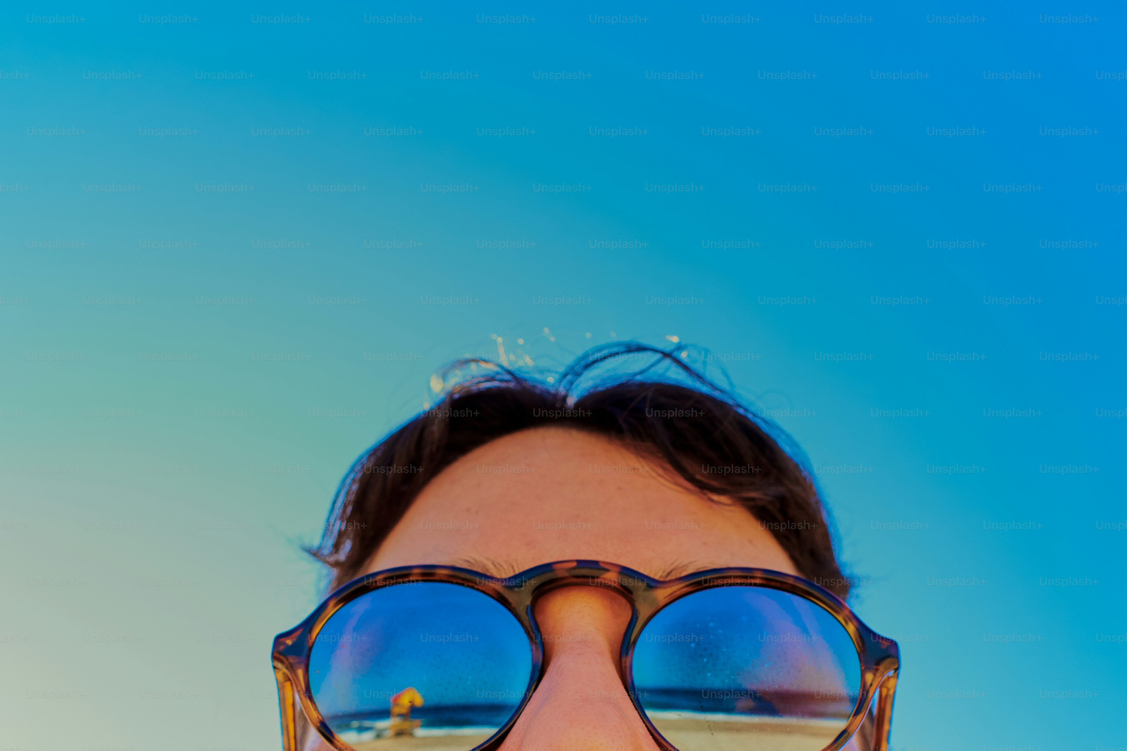 Sunglasses reflect a beach scene.