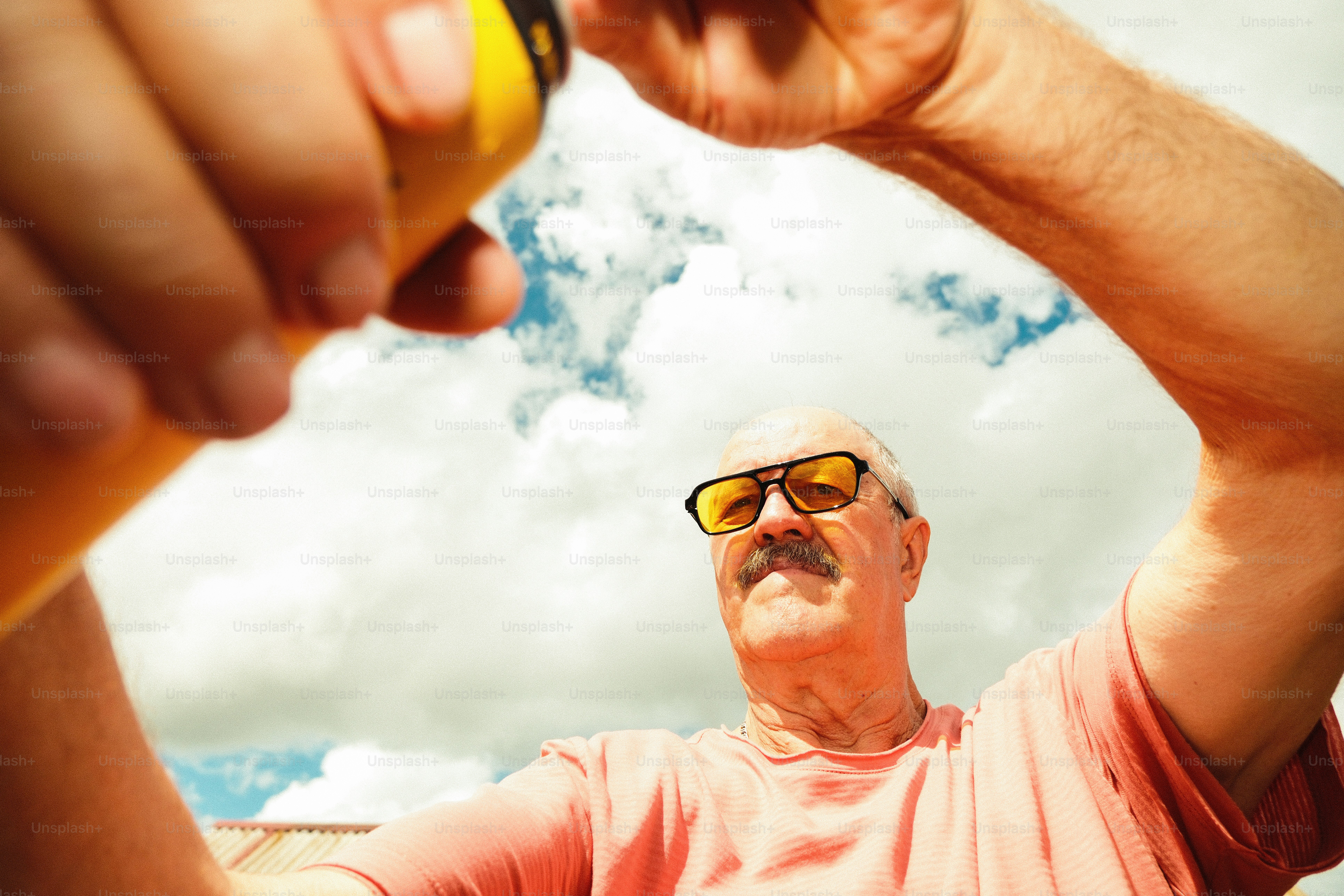 Mann trinkt aus einem gelben Behälter.