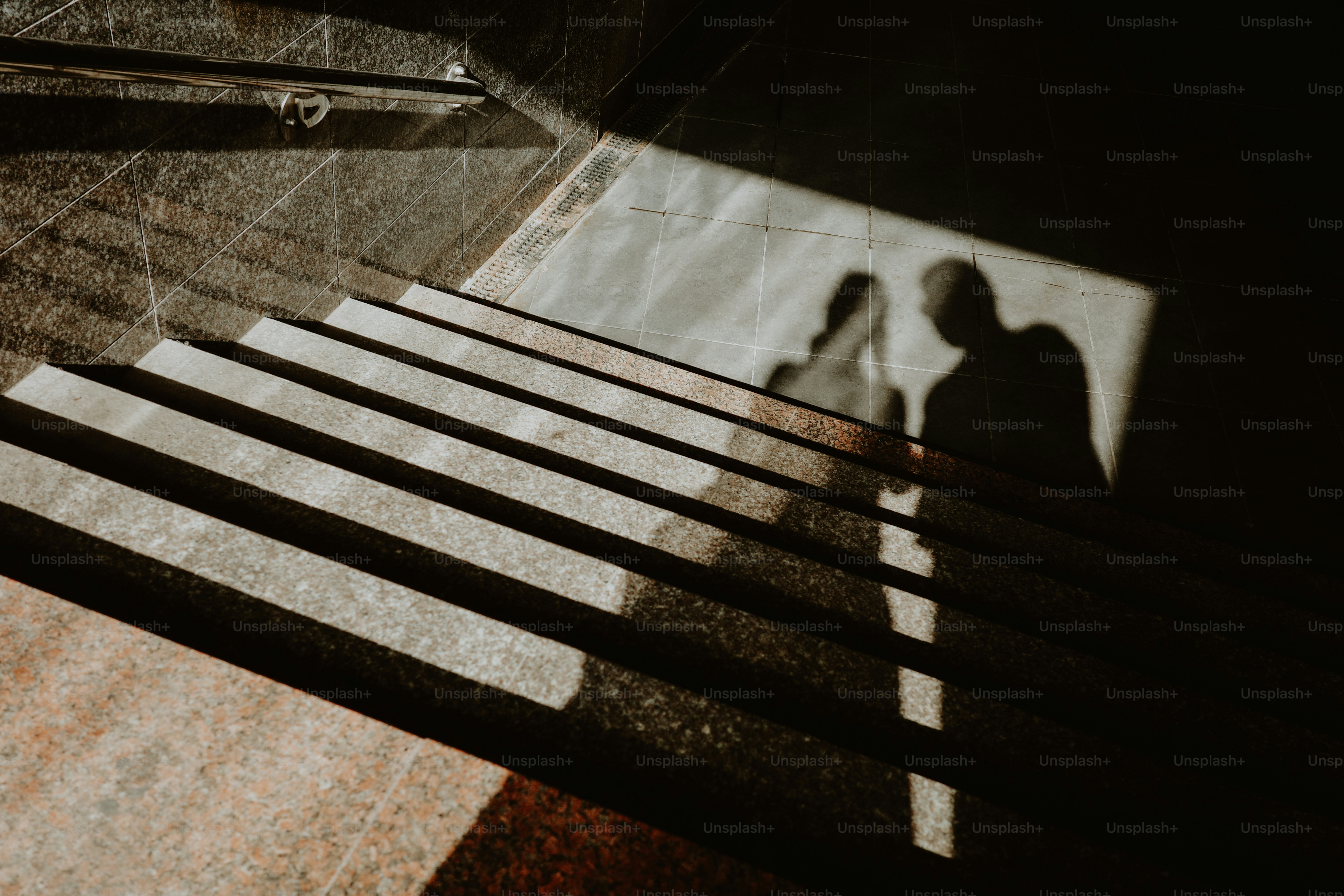 Shadows of a couple stand on the stairs. photo – Texture Image on Unsplash