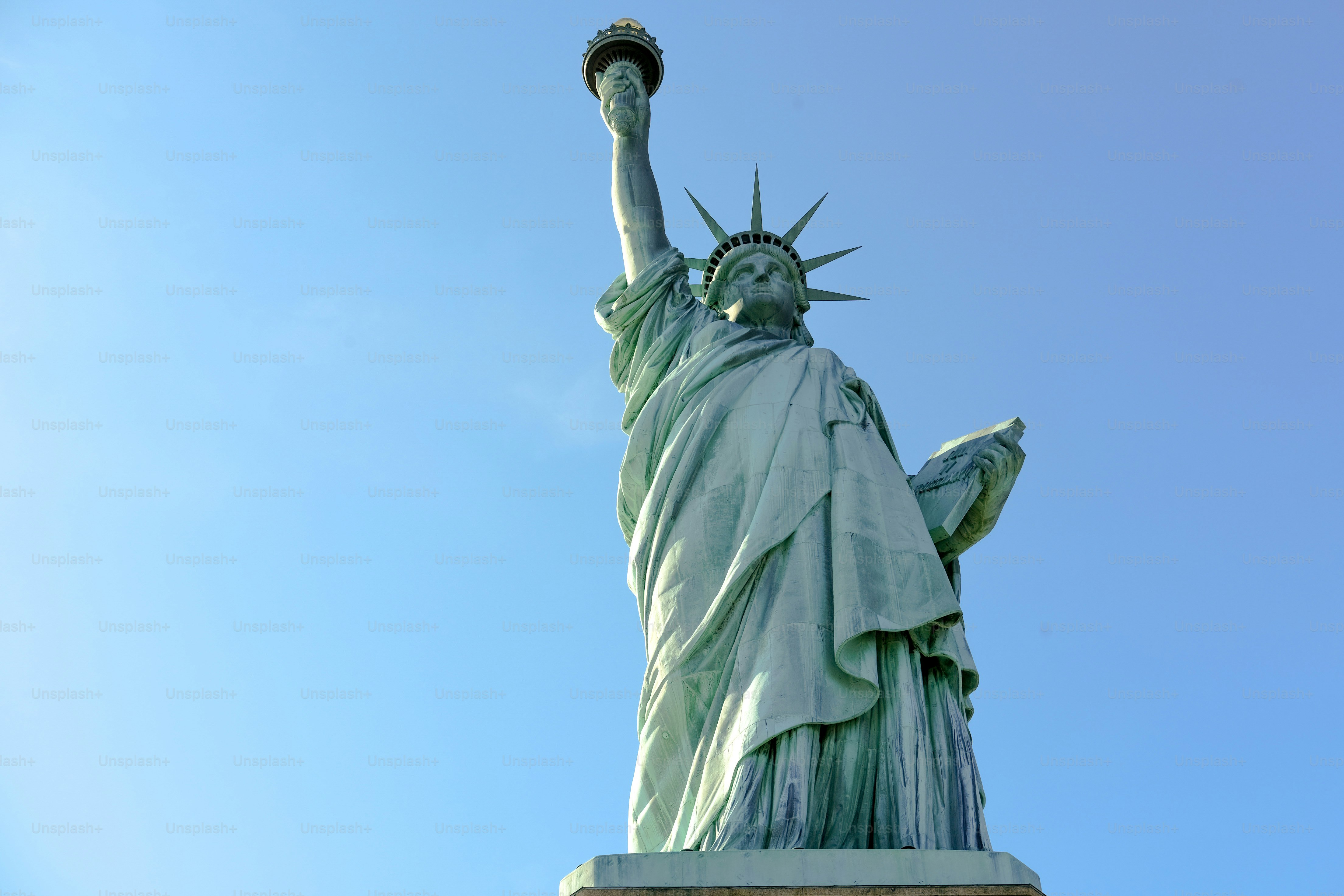 The statue of liberty stands tall against the sky.