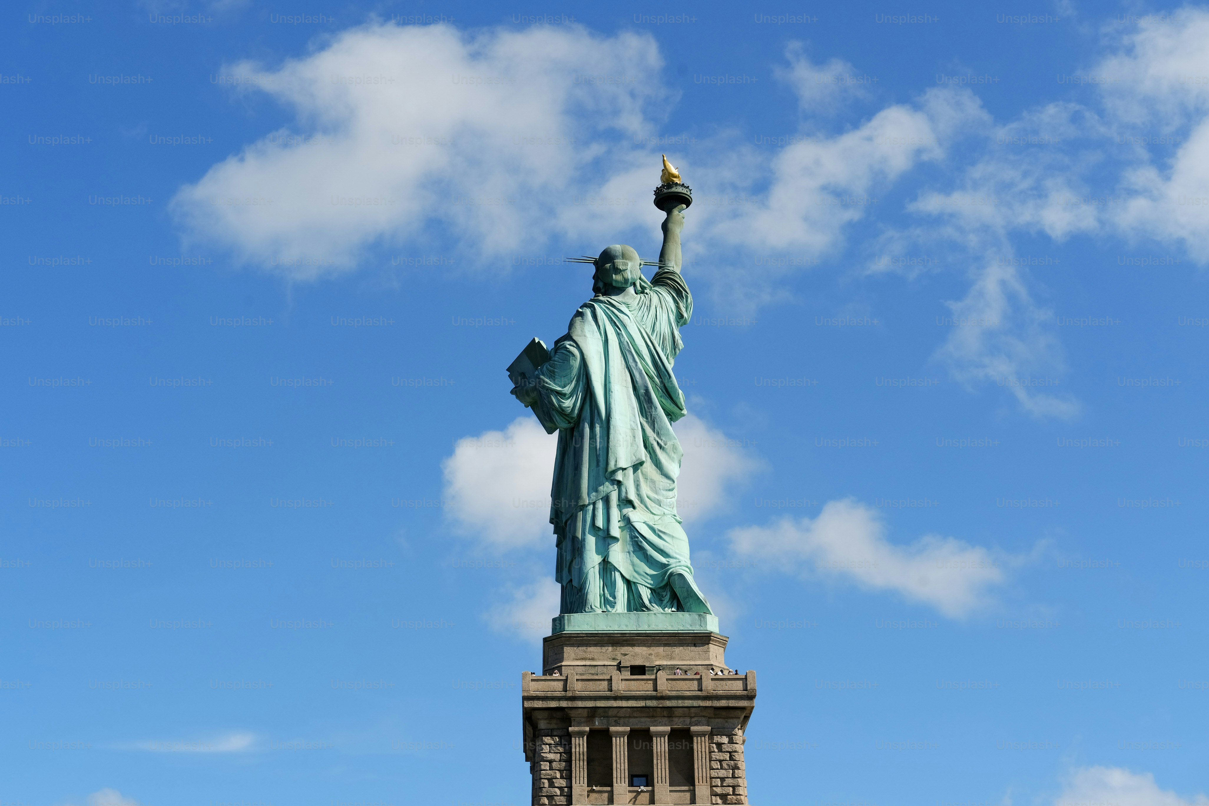 The statue of liberty stands tall against the sky.