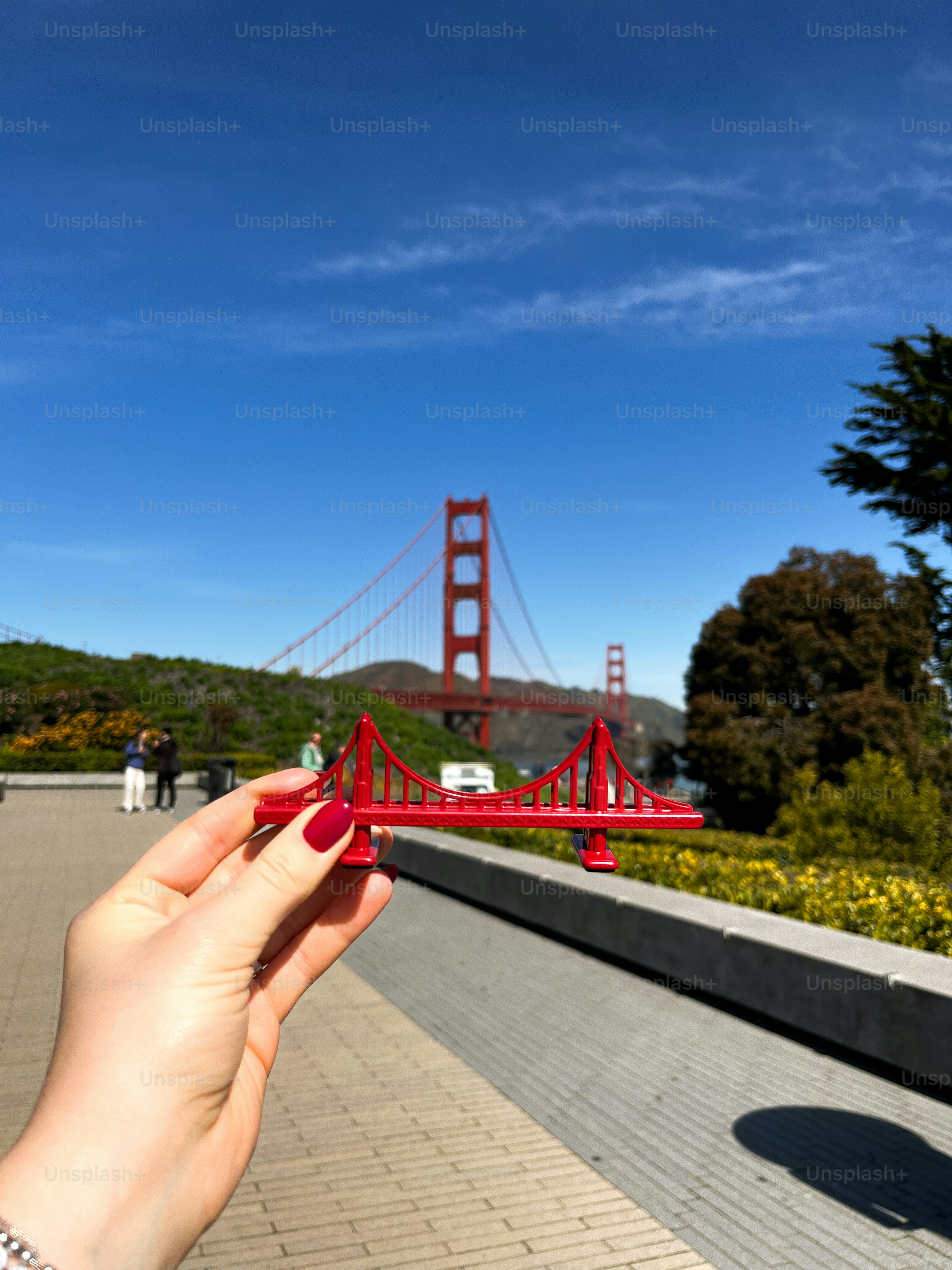 A hand holds a miniature golden gate bridge.