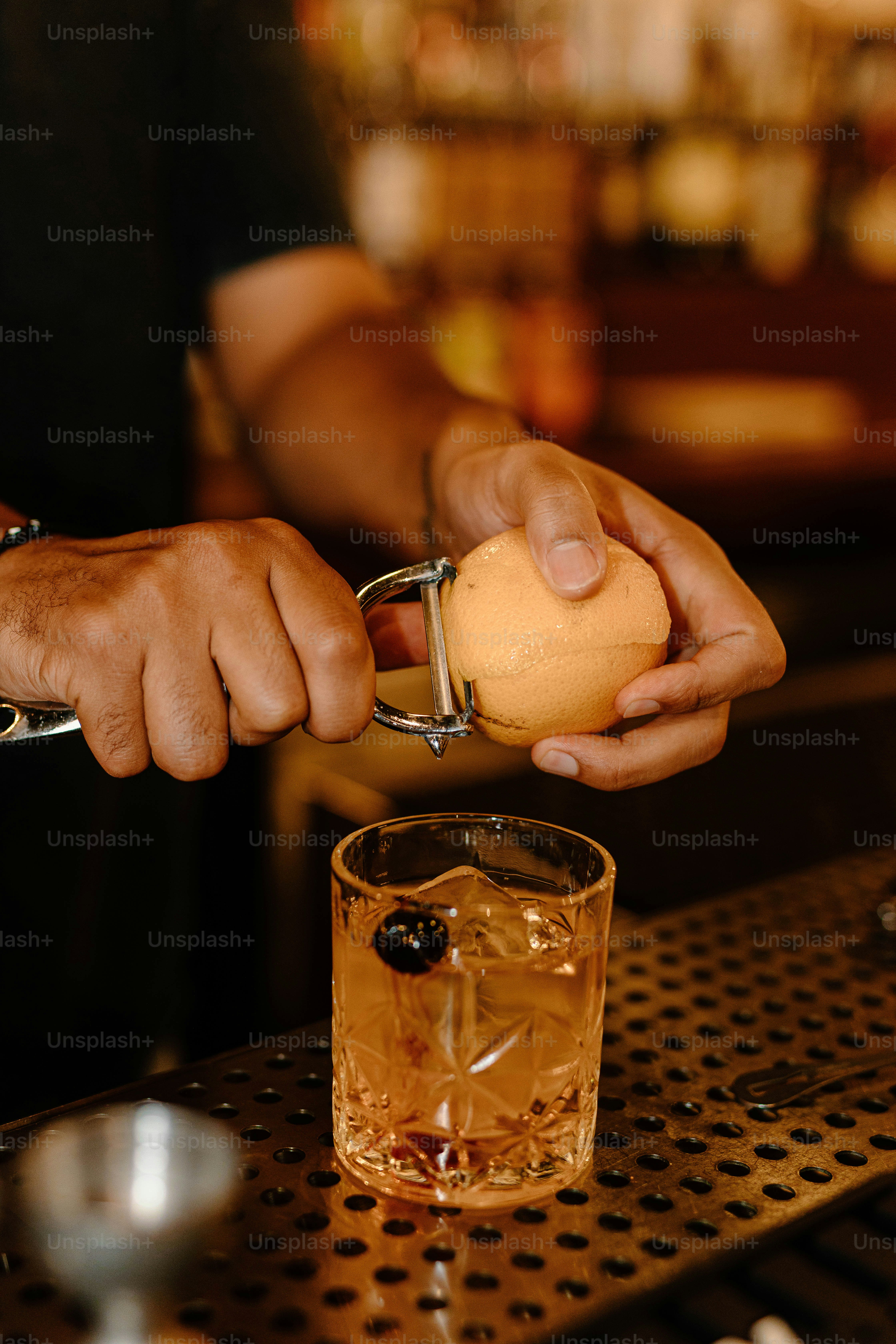 Bartender preparing a drink with an orange peel.