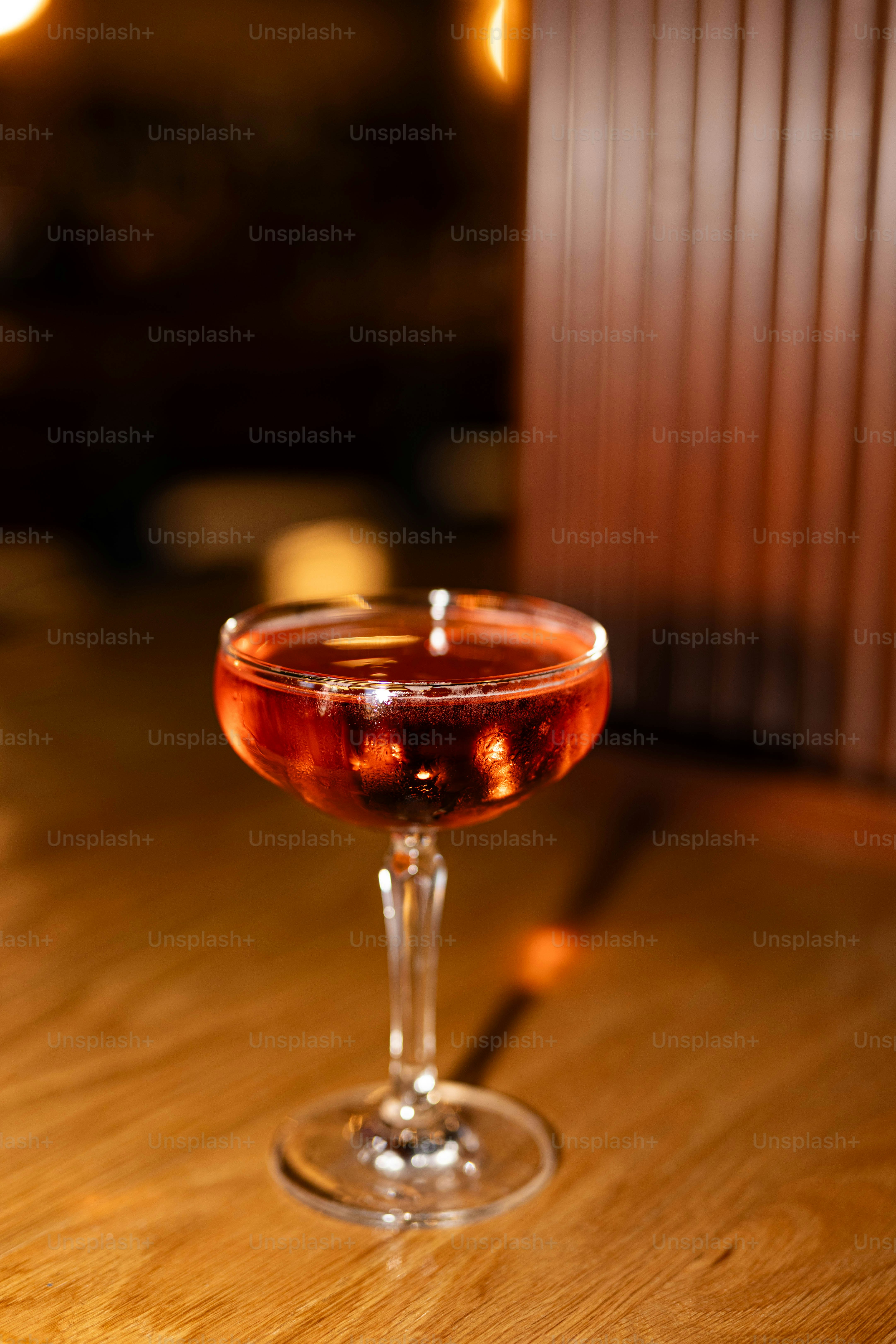 A cocktail sits on a wooden table.