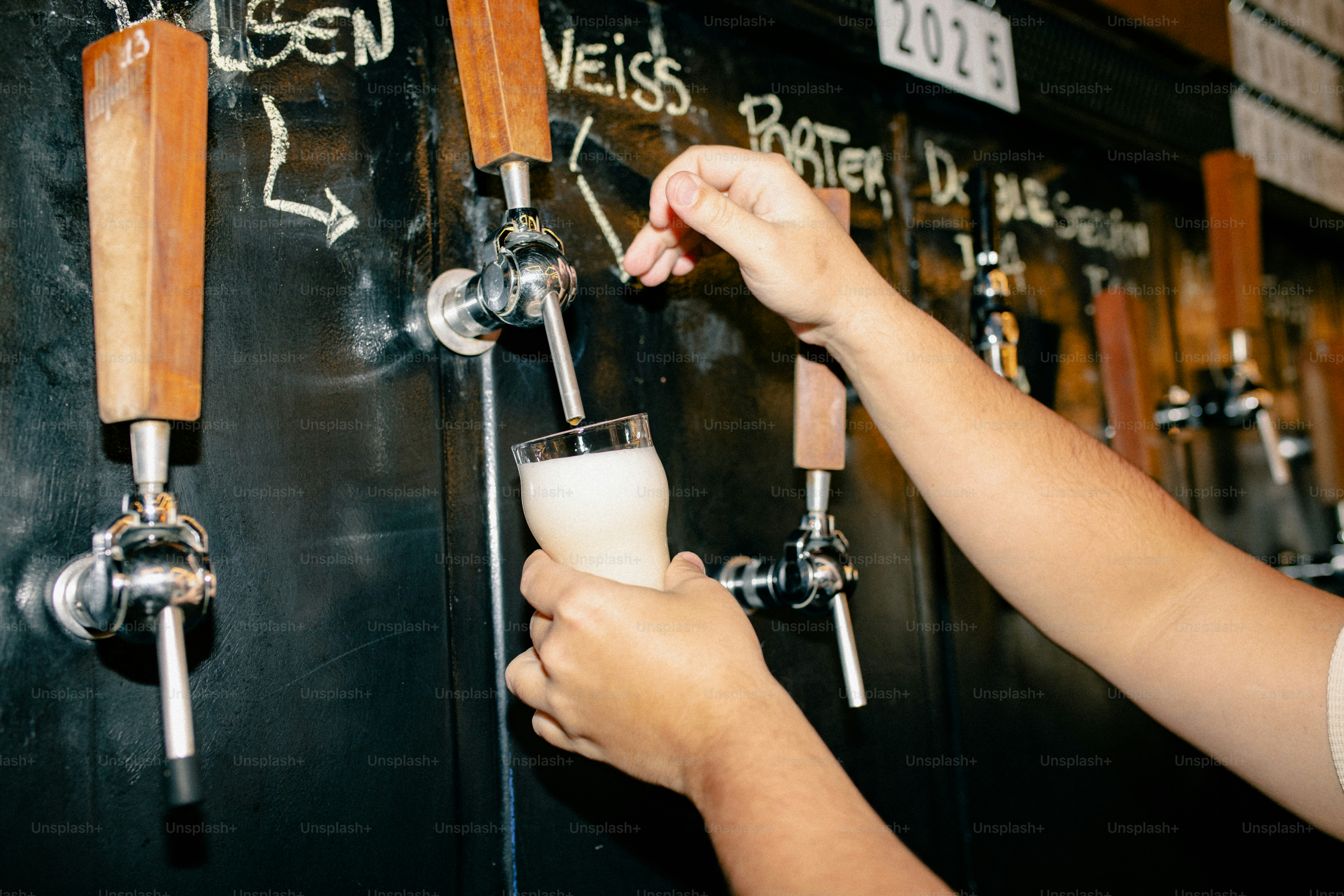 A hand pours beer from a tap.
