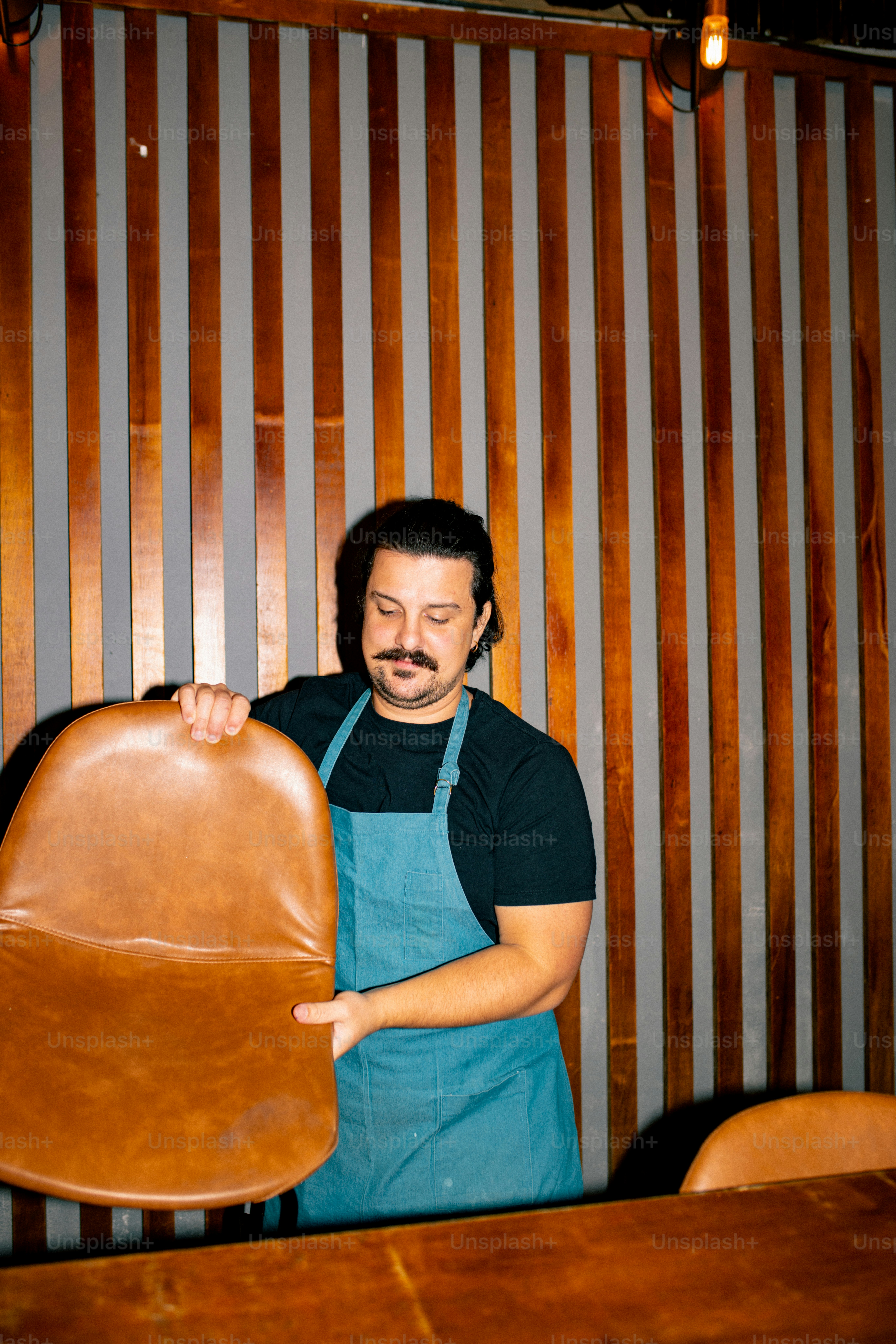 A man is holding a chair in a restaurant.