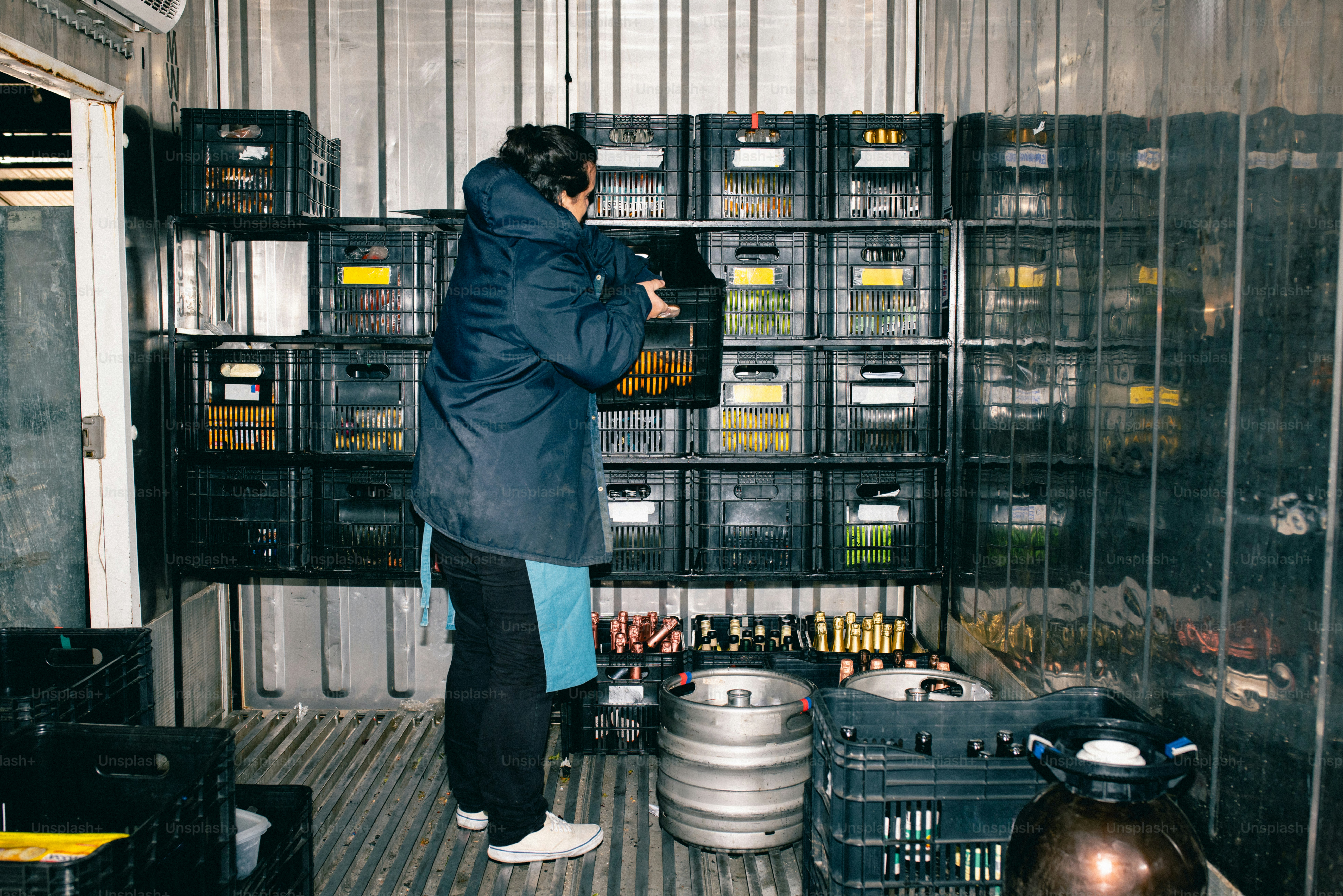 Une personne empile des caisses à l’intérieur d’une unité de stockage