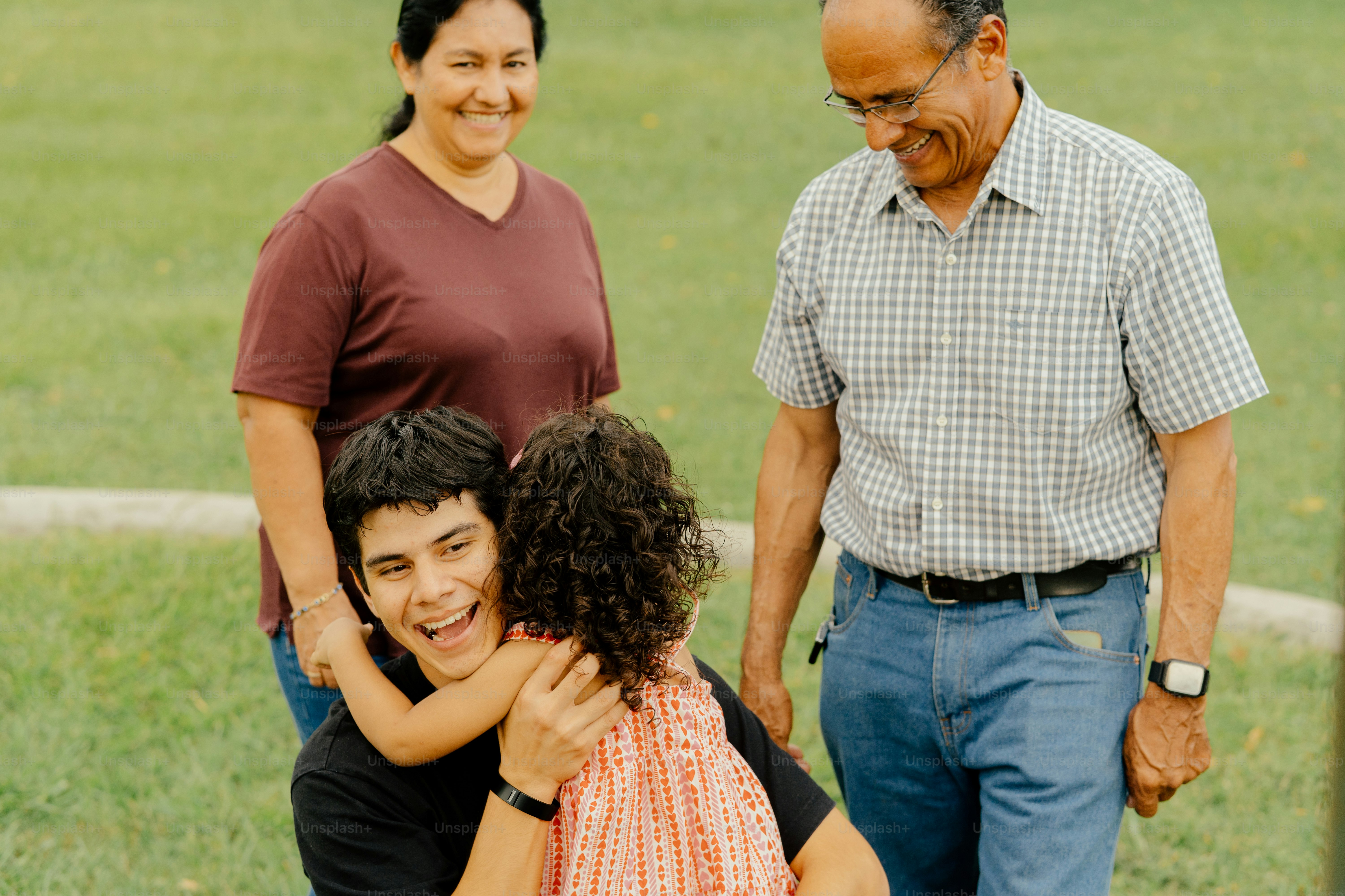 Family is happily embracing each other outdoors.