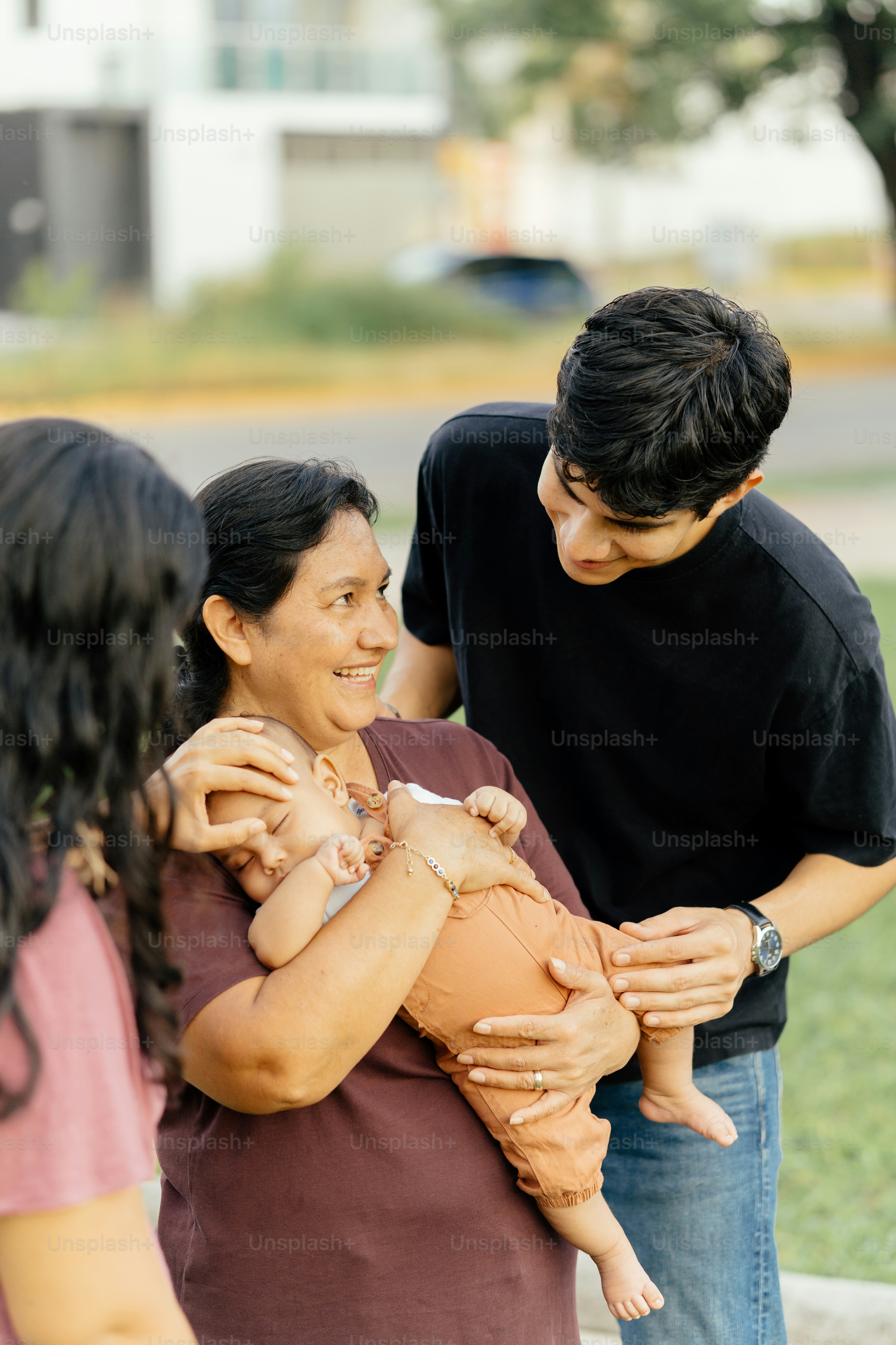 Family shares smiles while holding a baby.