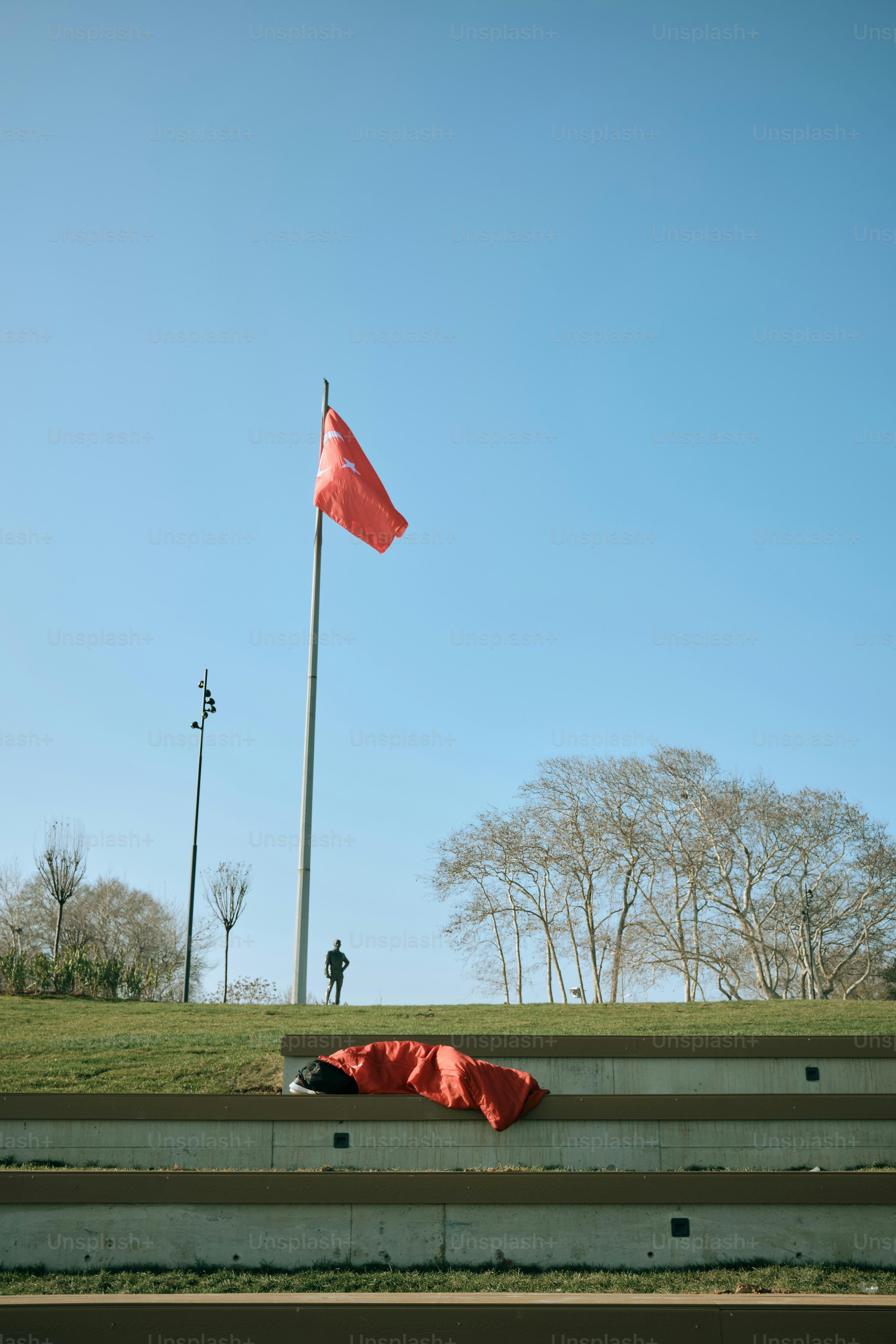 Turkish flag waves with a person on the hill.