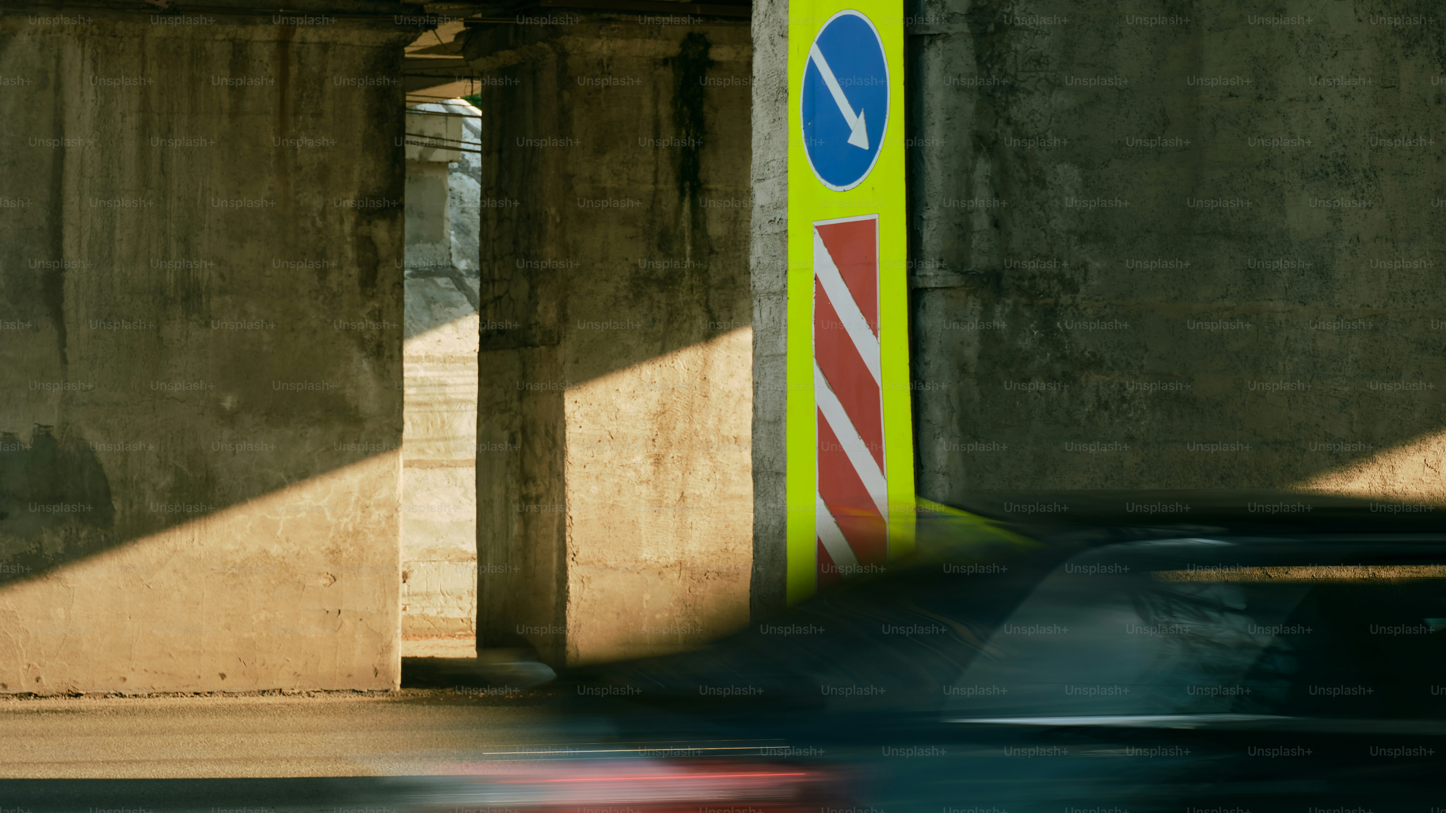 A road sign points down near concrete.
