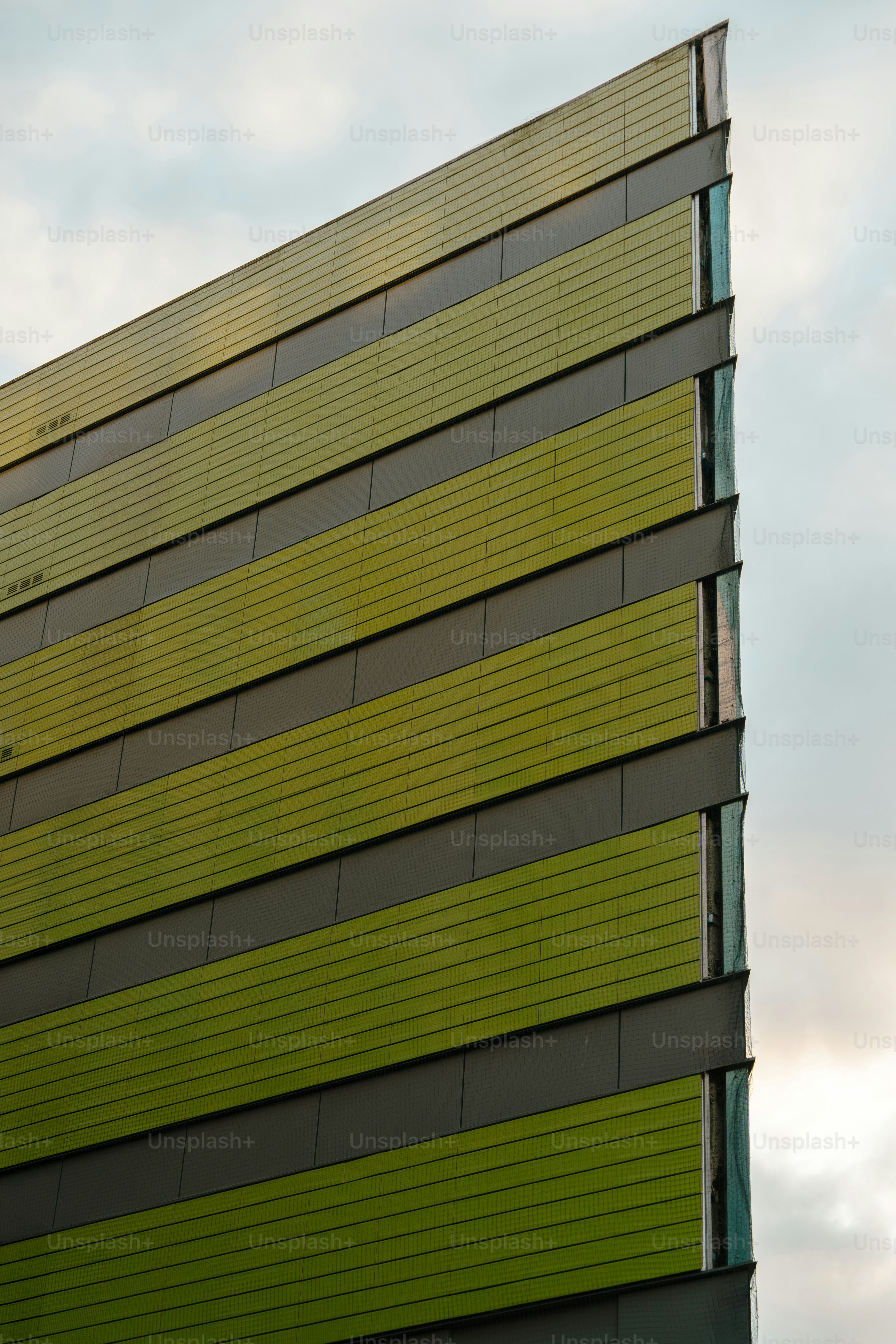 Modernes Gebäude mit gestreifter grüner Fassade.