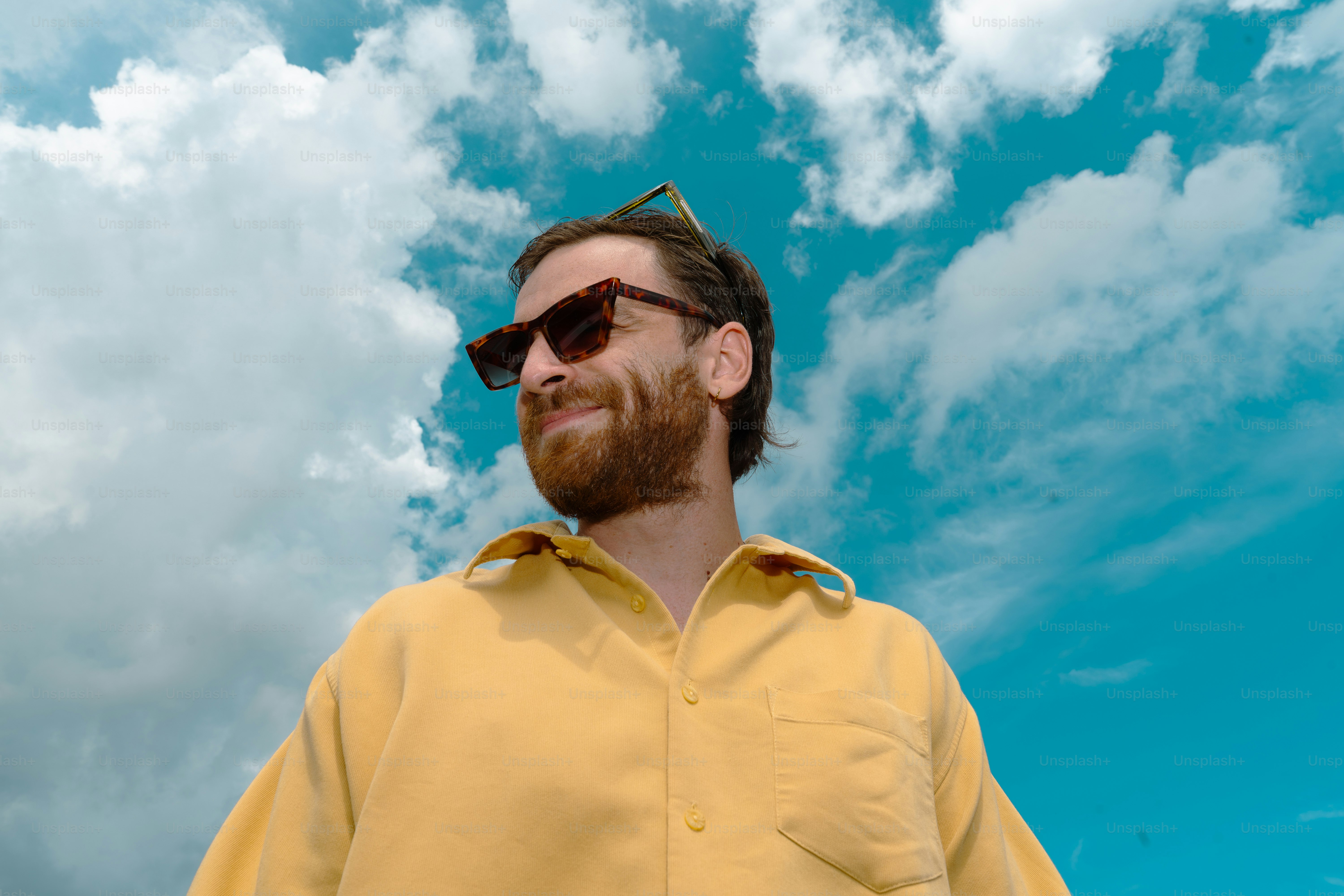 Mann mit Sonnenbrille und Blick in den Himmel.