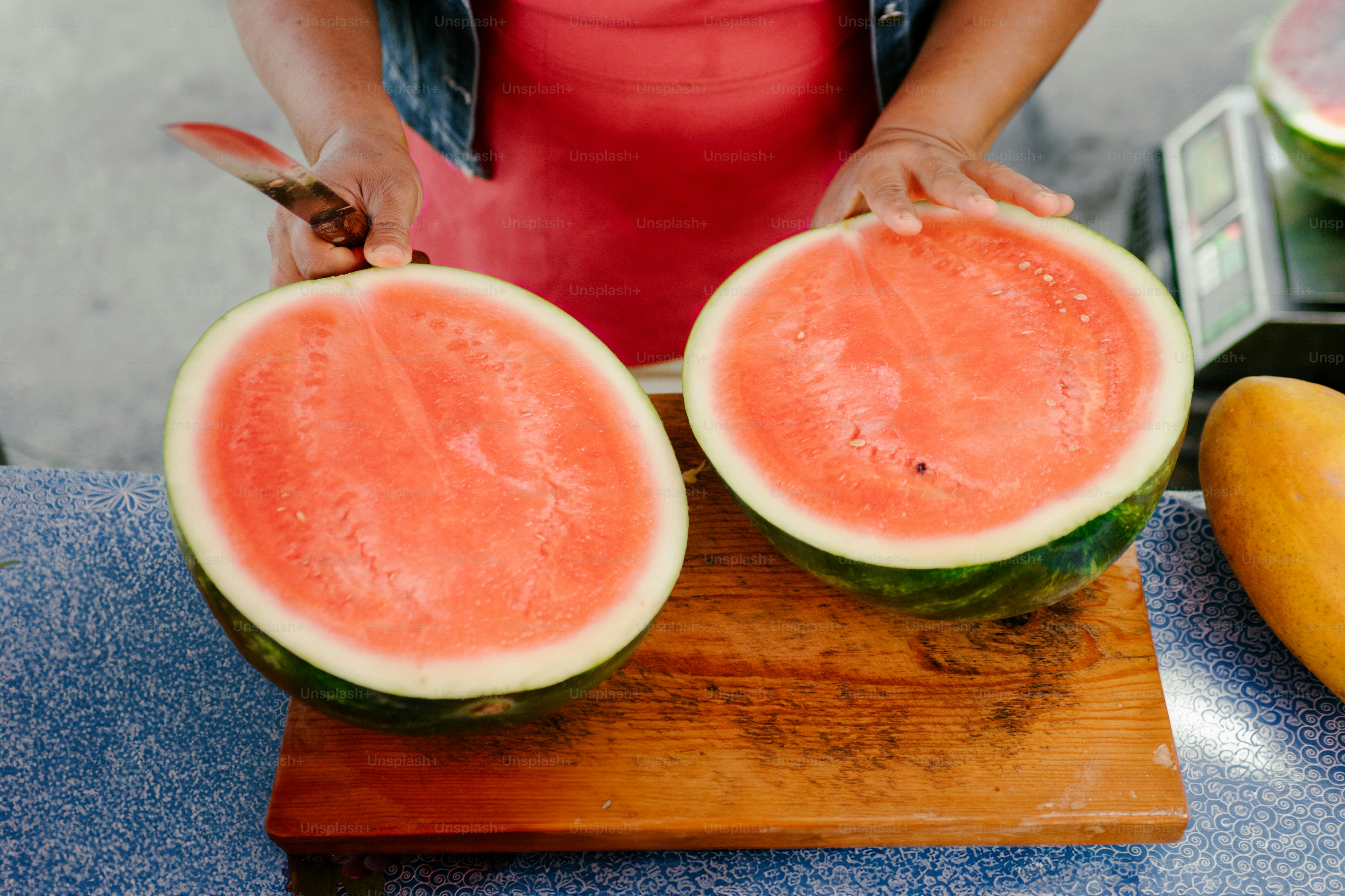A watermelon is cut in half and ready to eat.