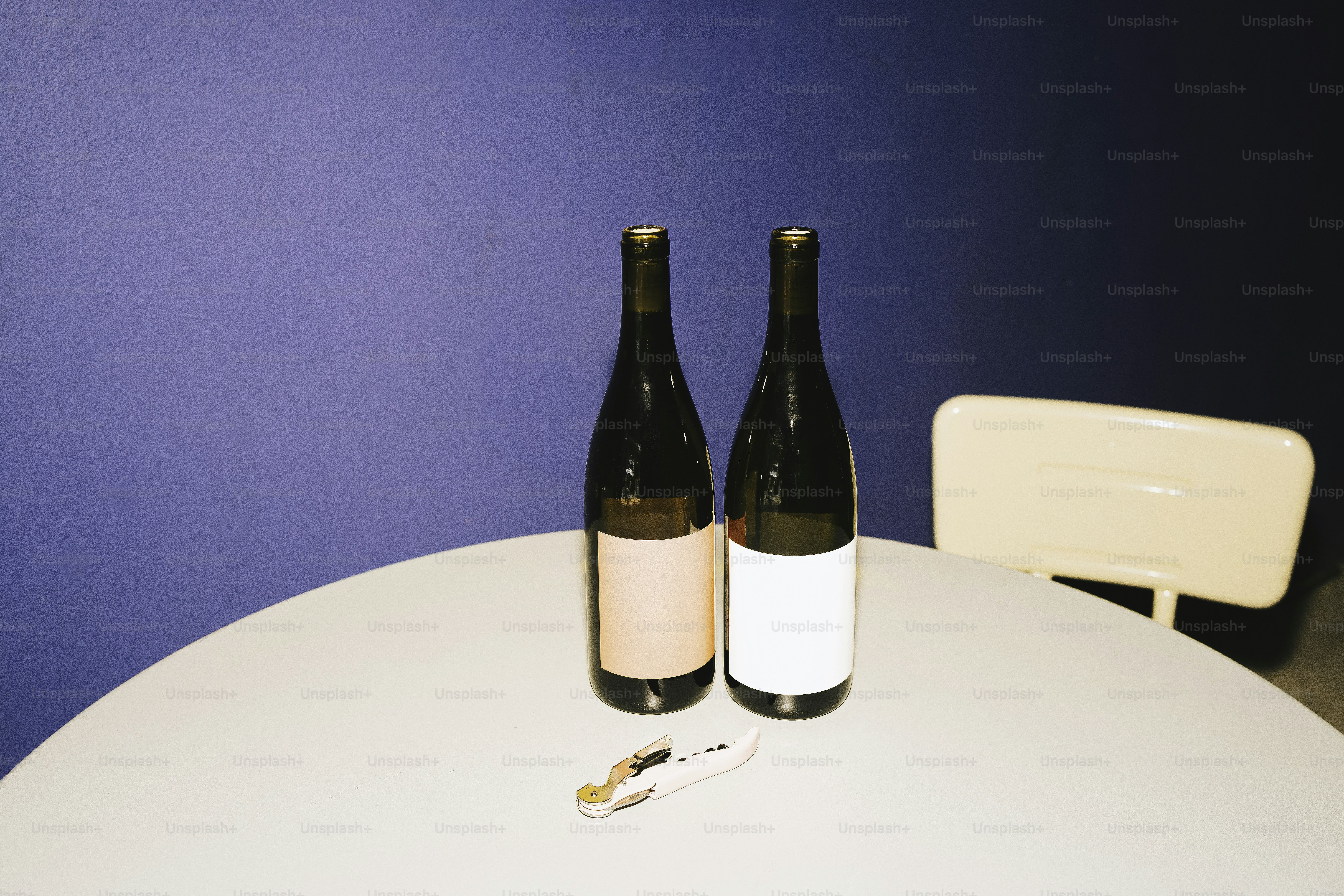 Deux bouteilles de vin sont posées sur une table ronde.
