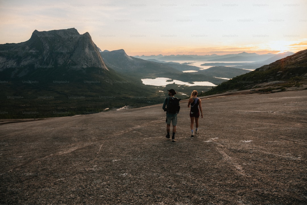 Two hikers enjoy the mountain views at sunset.
