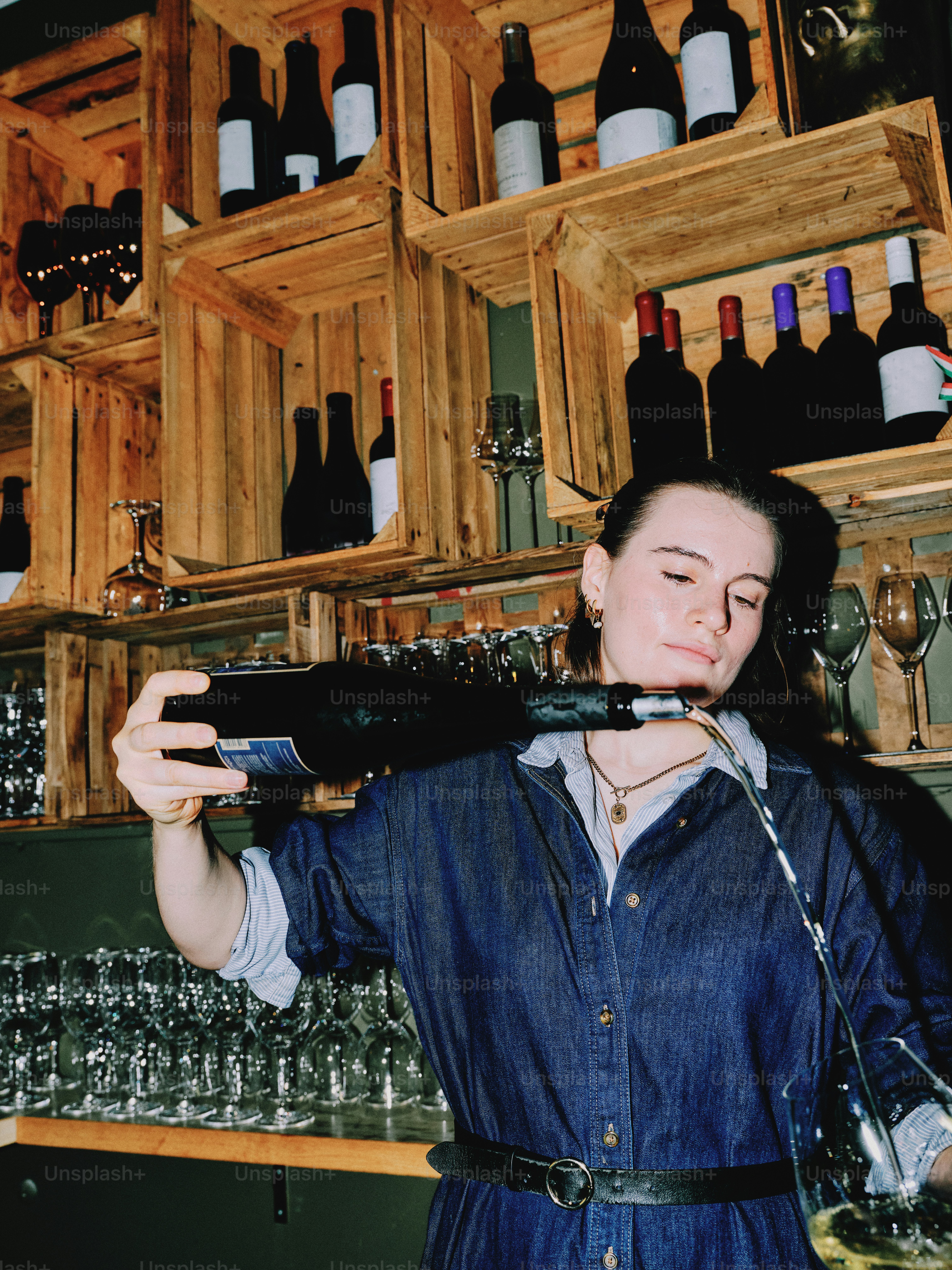 A bartender pours wine into a waiting glass. photo – Portrait Image on ...