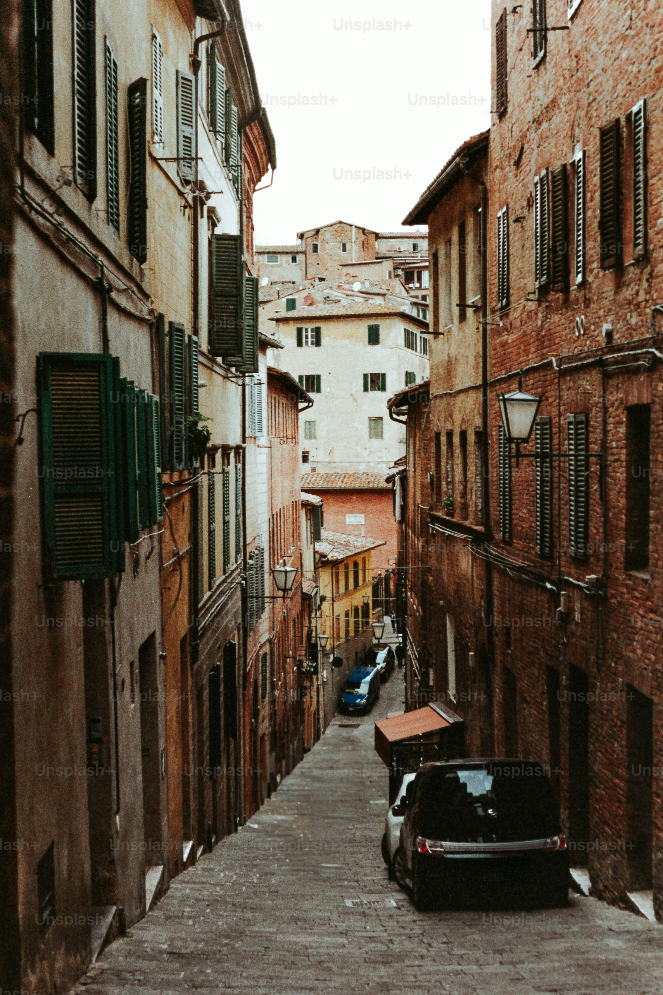 Narrow italian street leads towards a building.