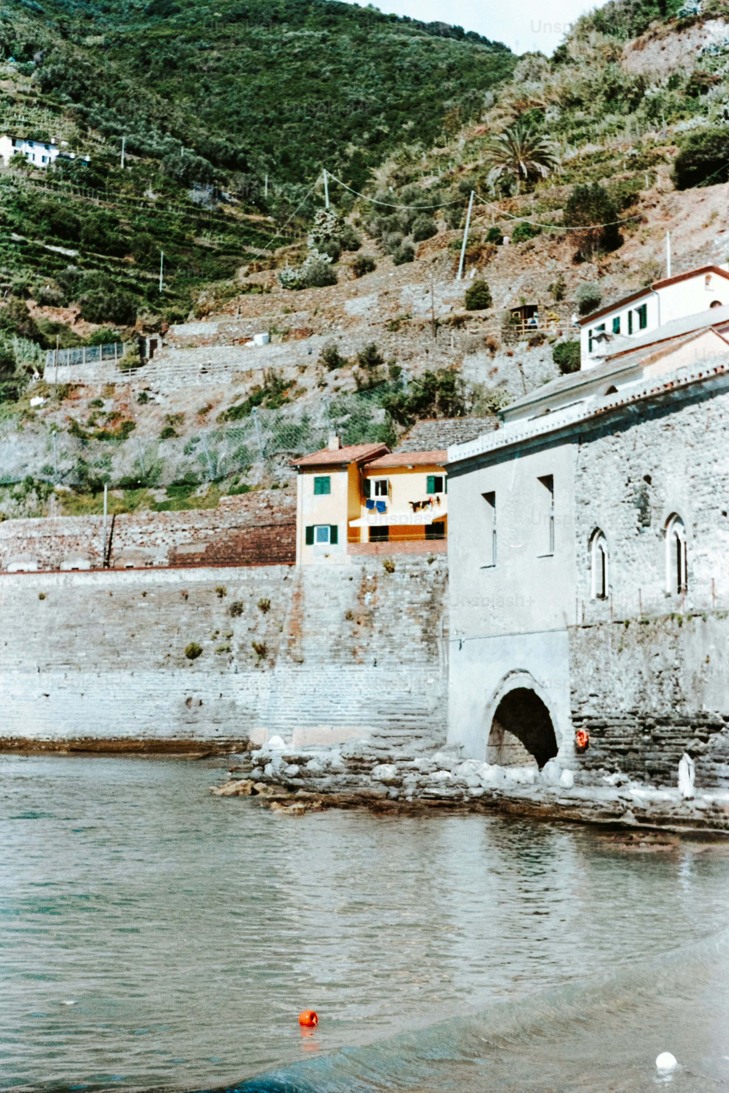 Coastal buildings nestle on a hillside near the water.