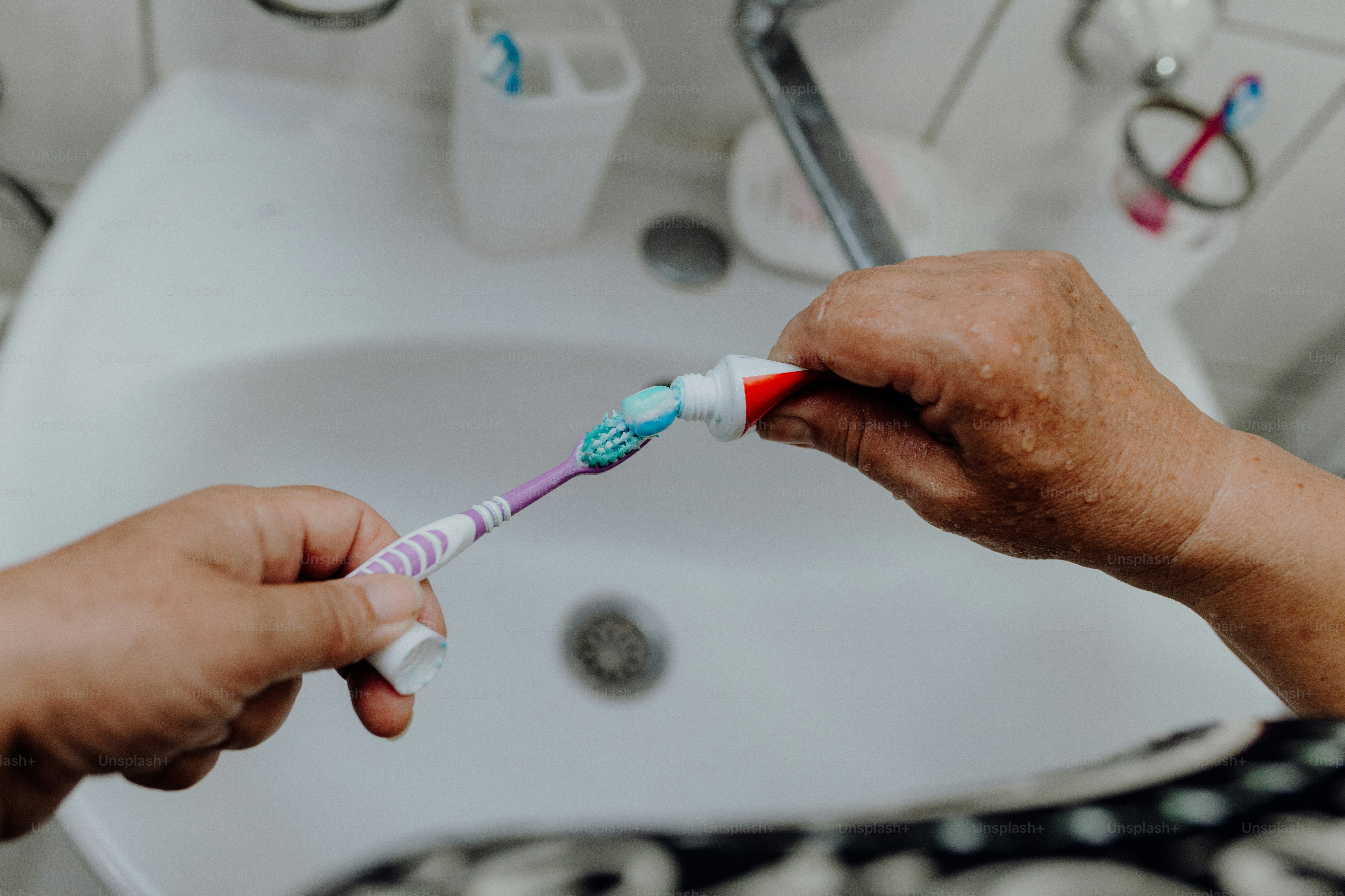 Someone is applying toothpaste to a toothbrush. photo – Hands Image on ...