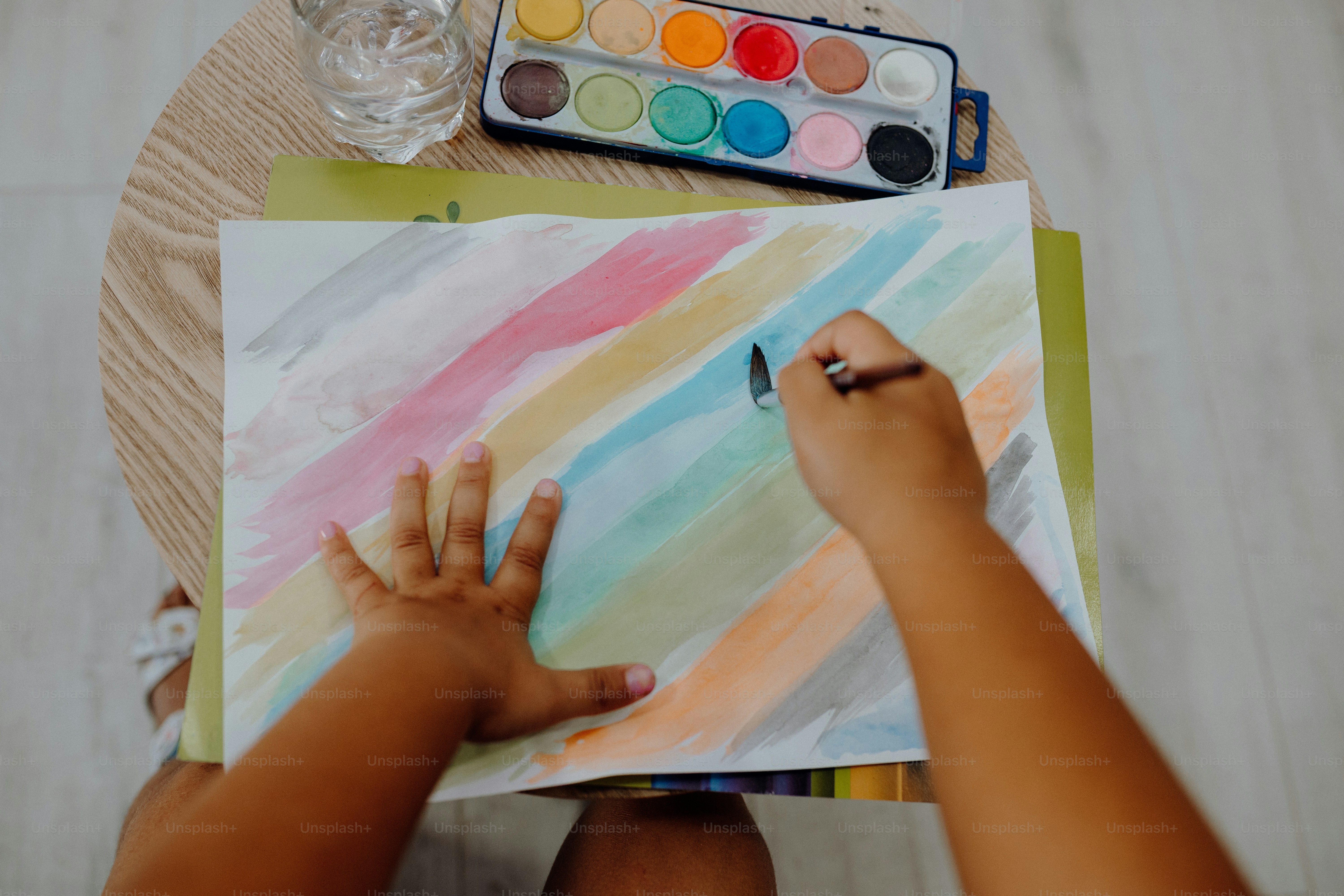 A child is painting with watercolors.