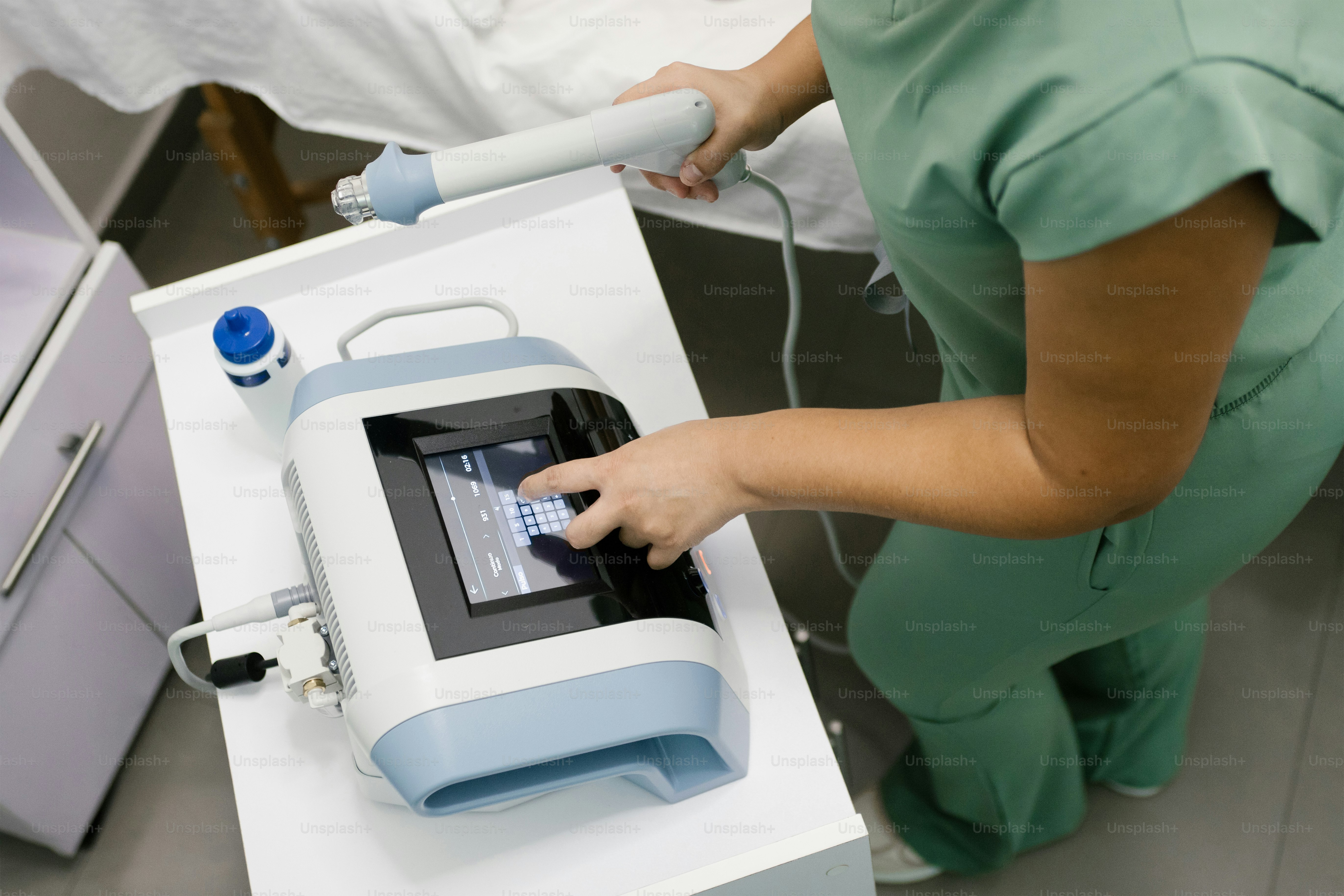 A nurse adjusts a medical machine. photo – Doctor Image on Unsplash