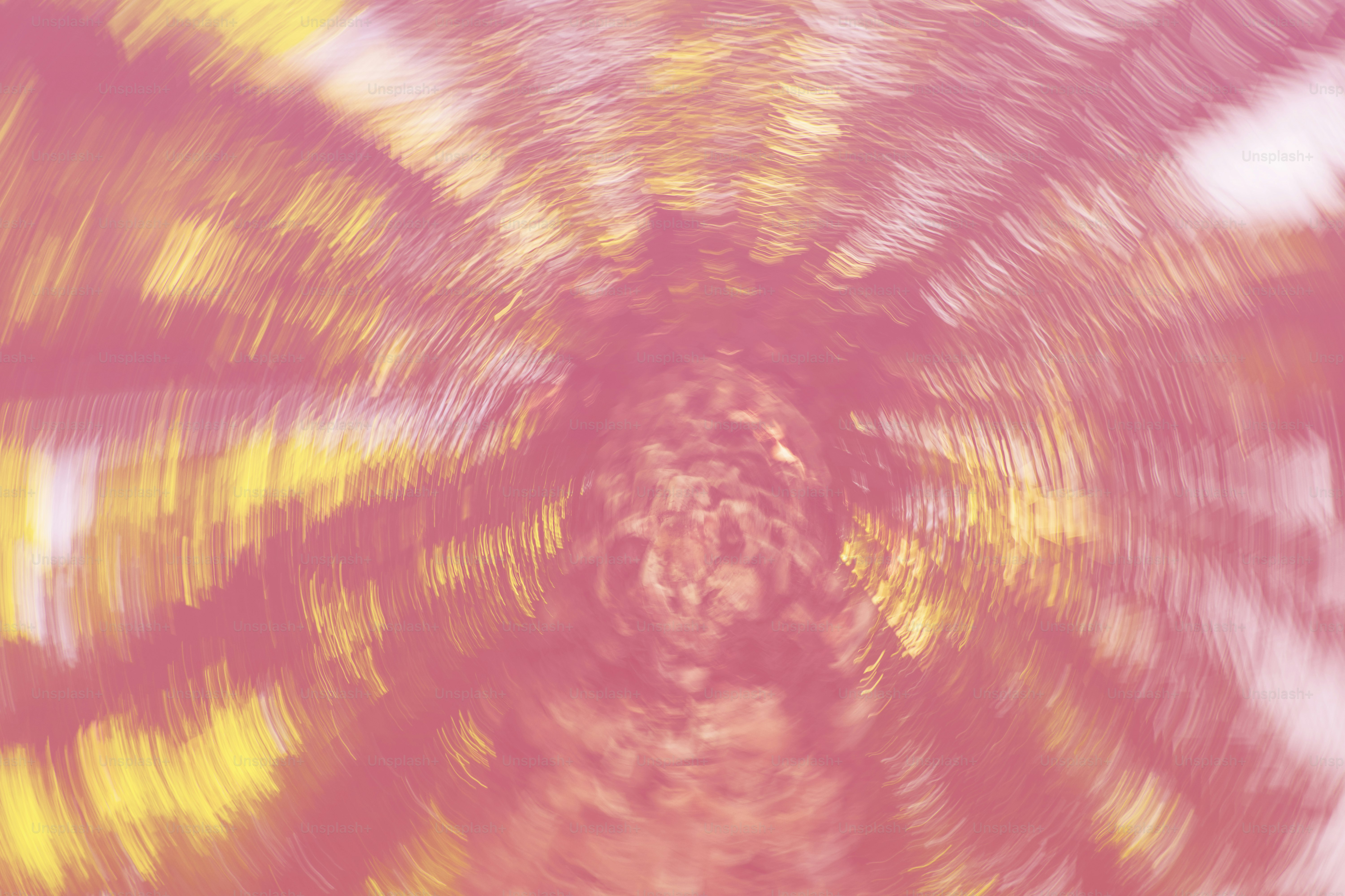 Abstract pink and yellow vortex swirls inward.