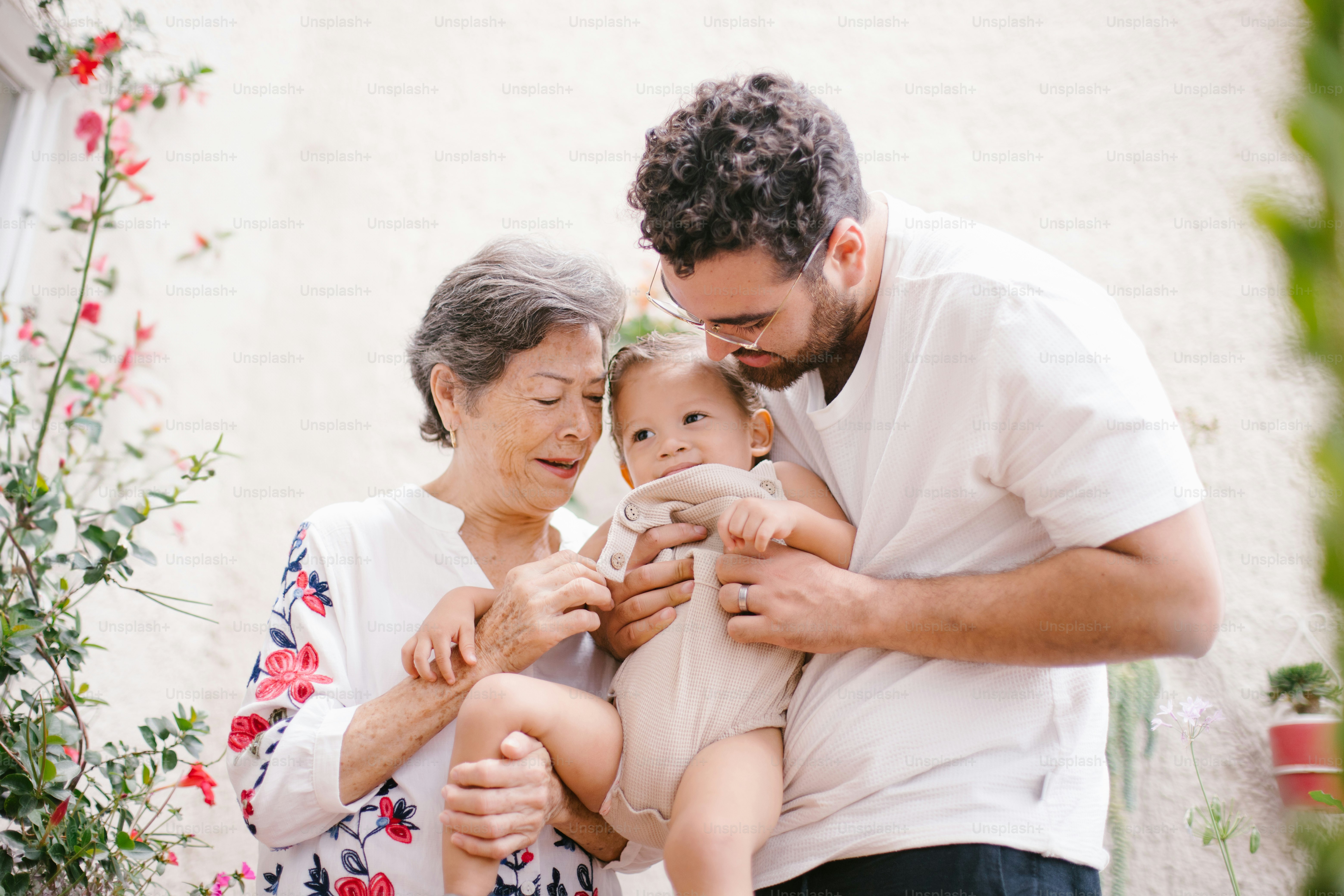 Grandmother, father, and baby bonding together.