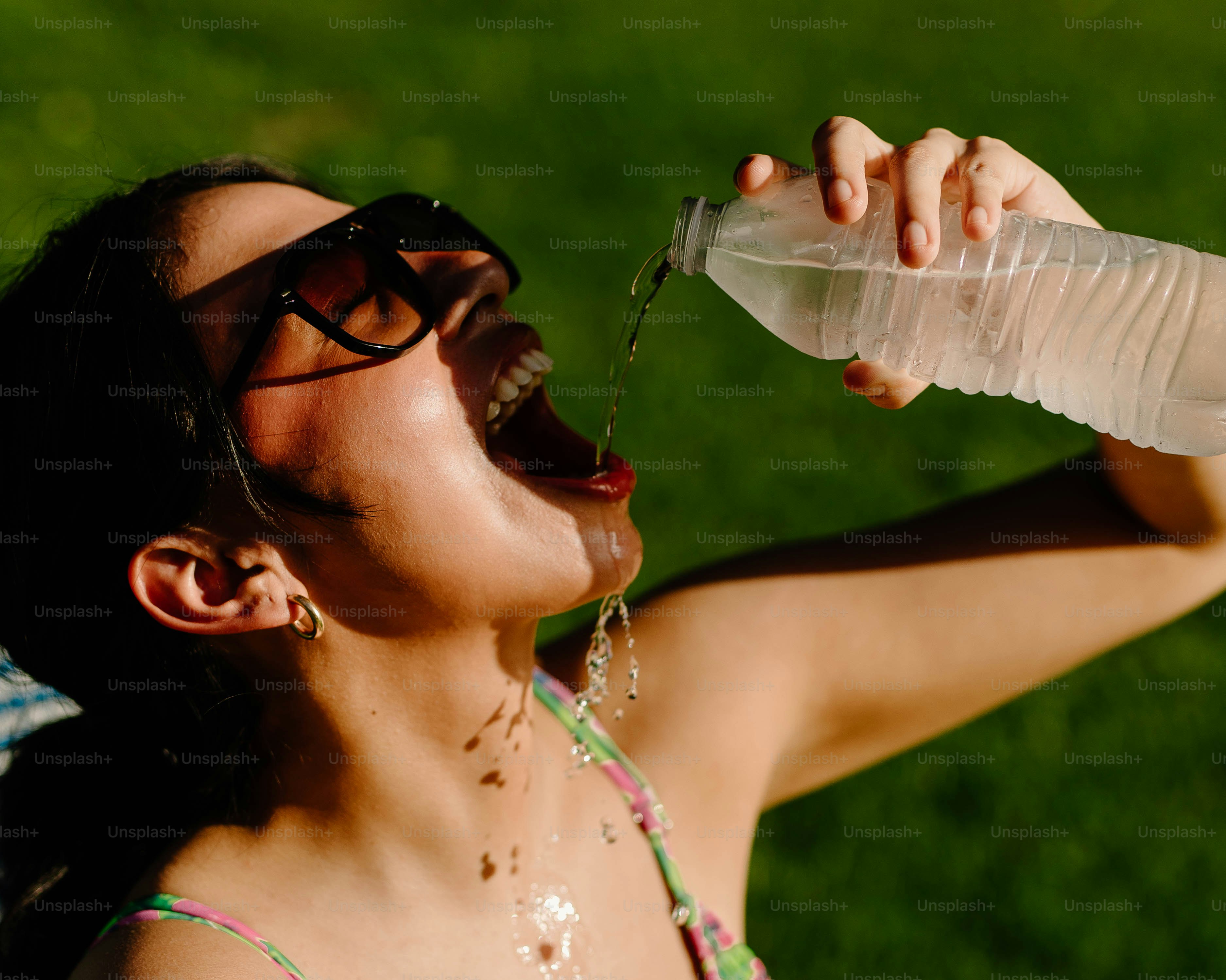 Woman quenches thirst by drinking water.