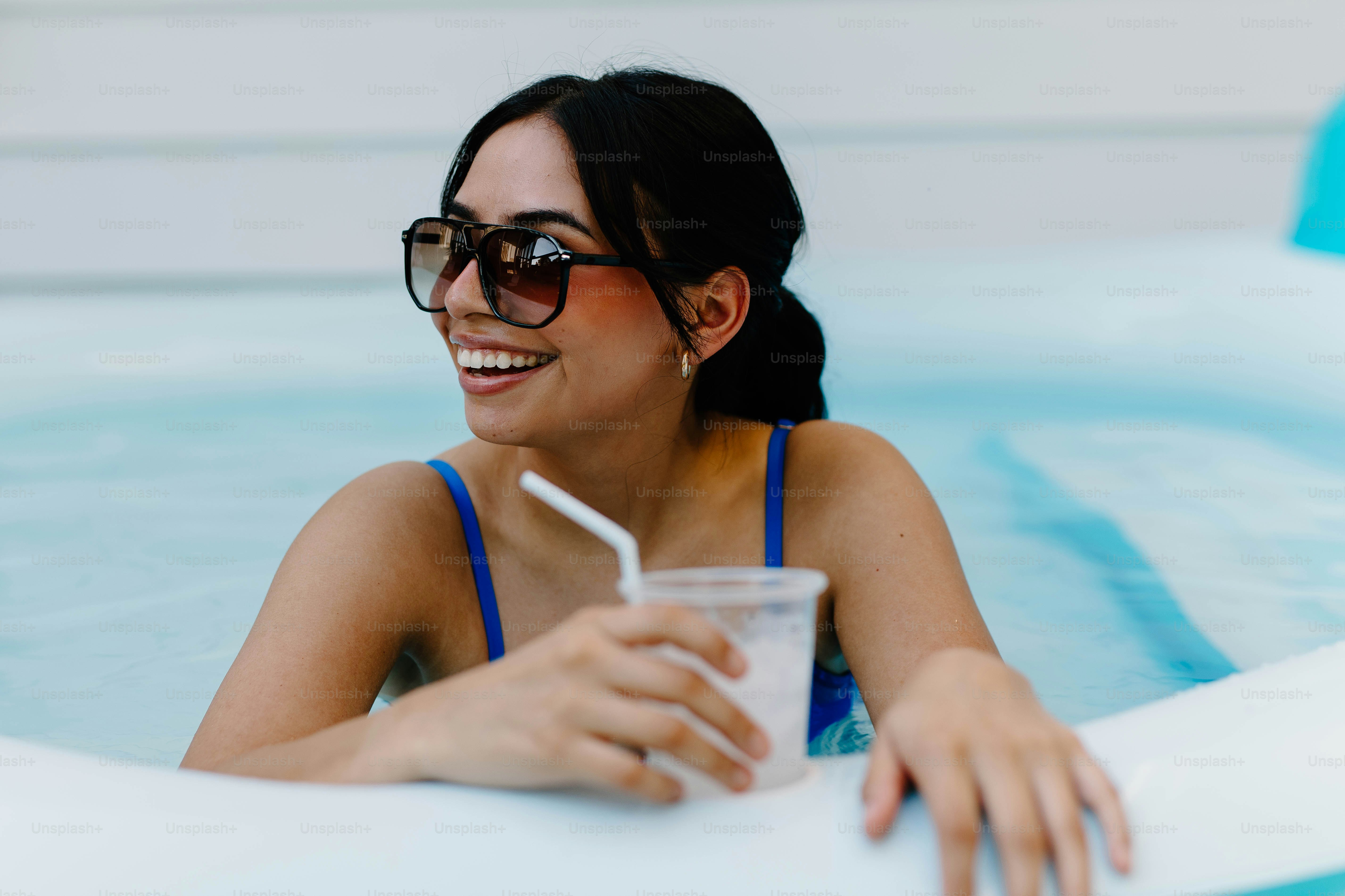 Mulher desfruta de uma bebida em uma piscina refrescante