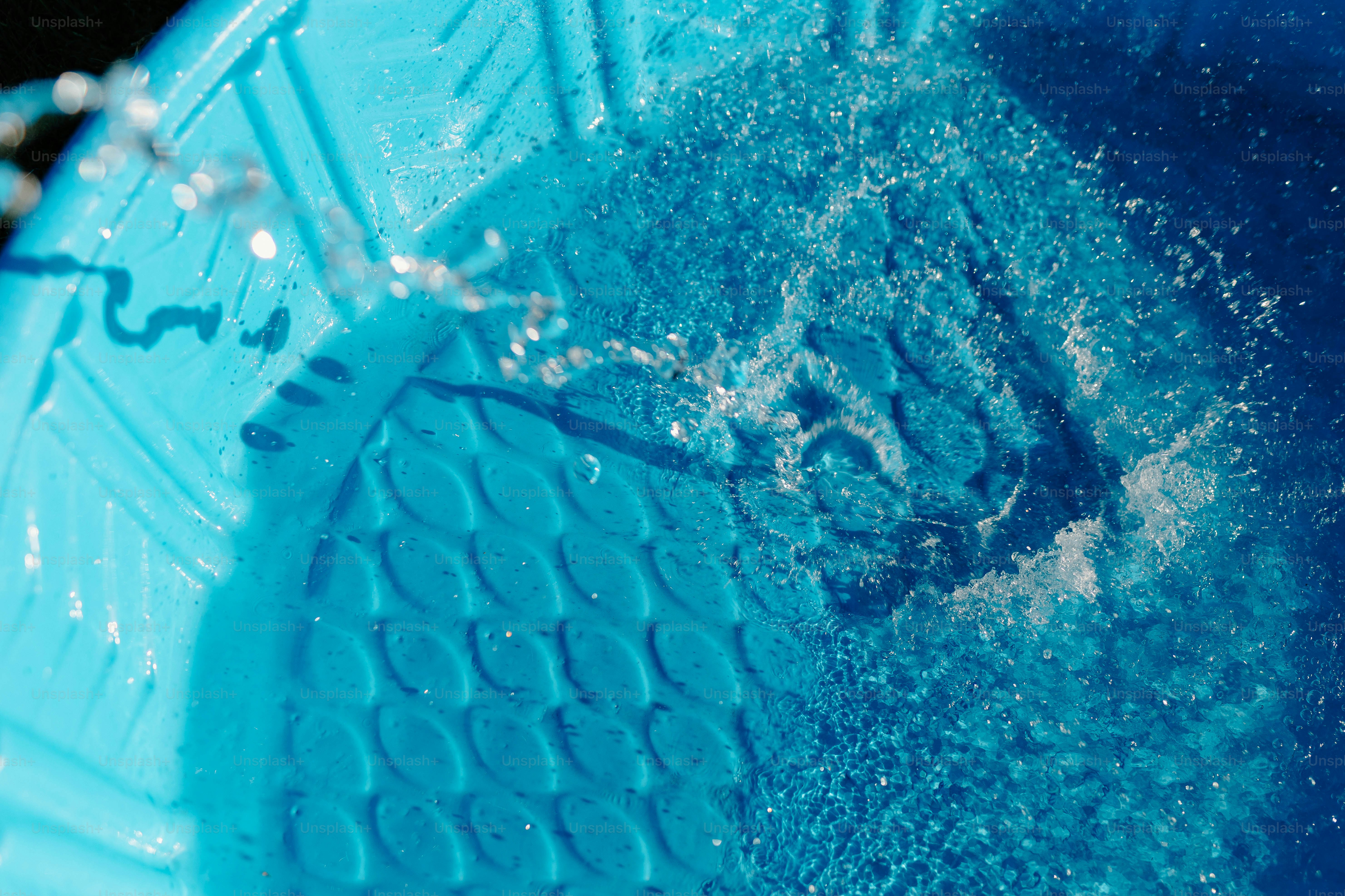 L’eau éclabousse à l’intérieur d’un récipient en plastique bleu