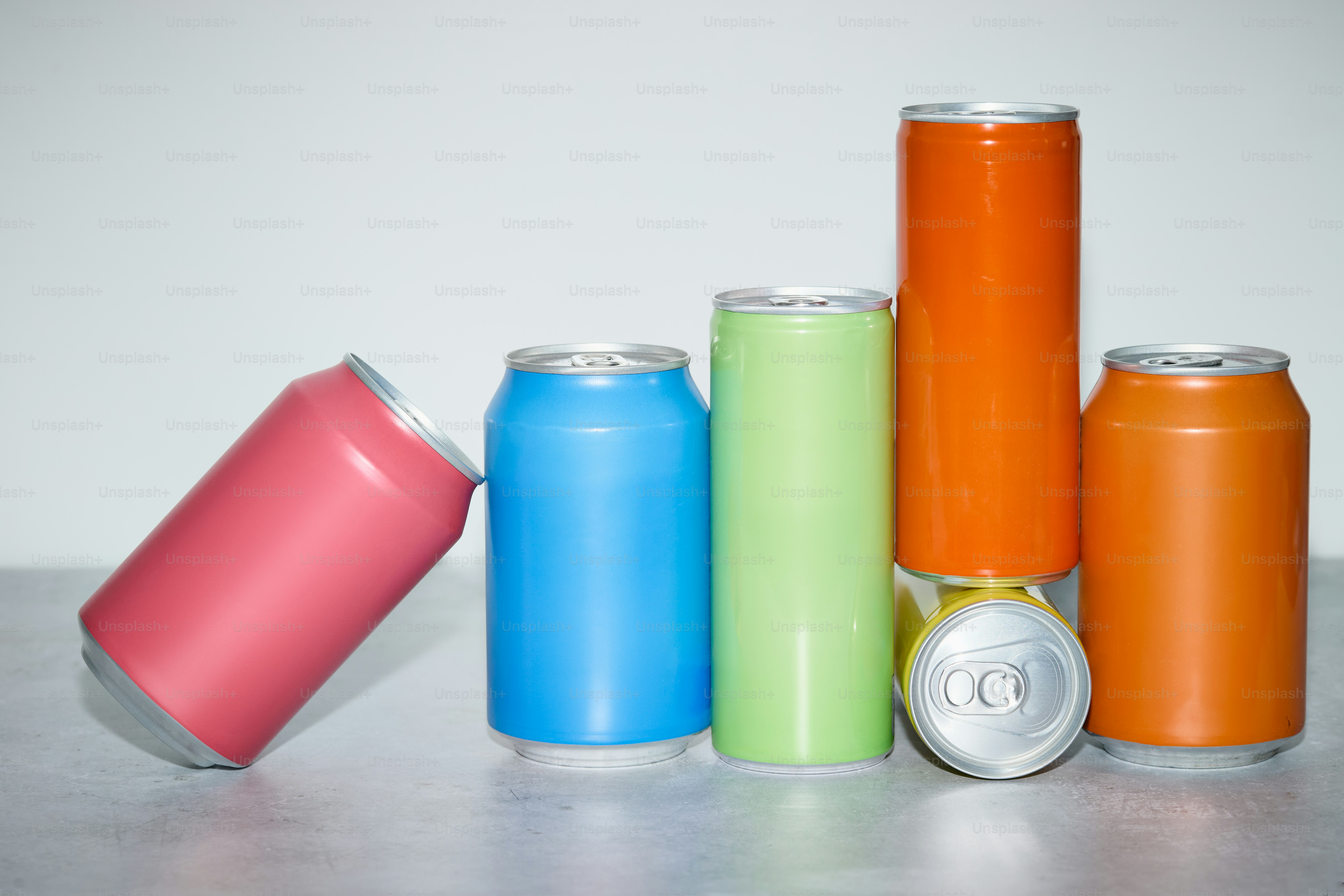 Colorful soda cans are arranged in a haphazard fashion.