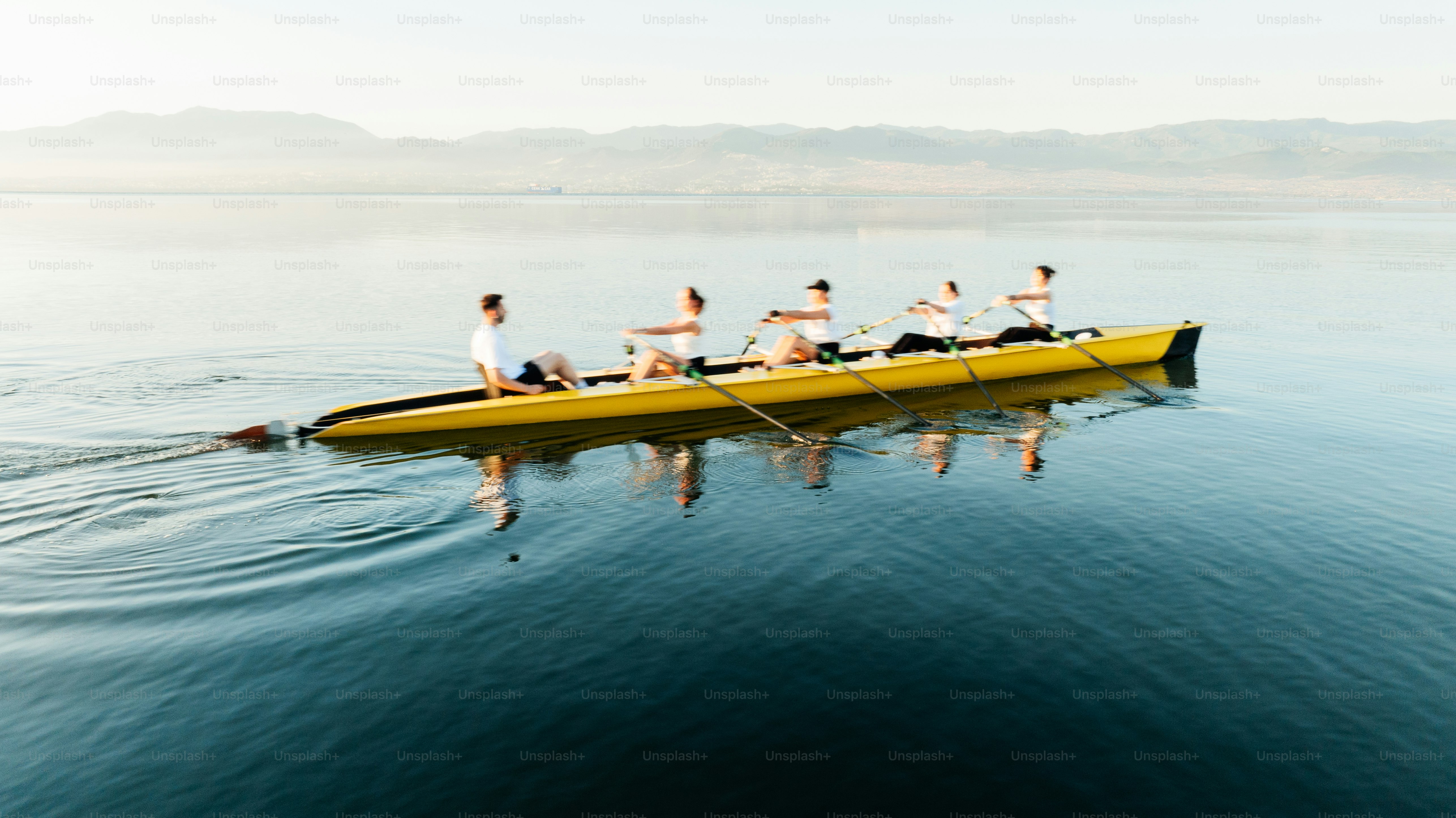 Rowers are practicing on a calm lake