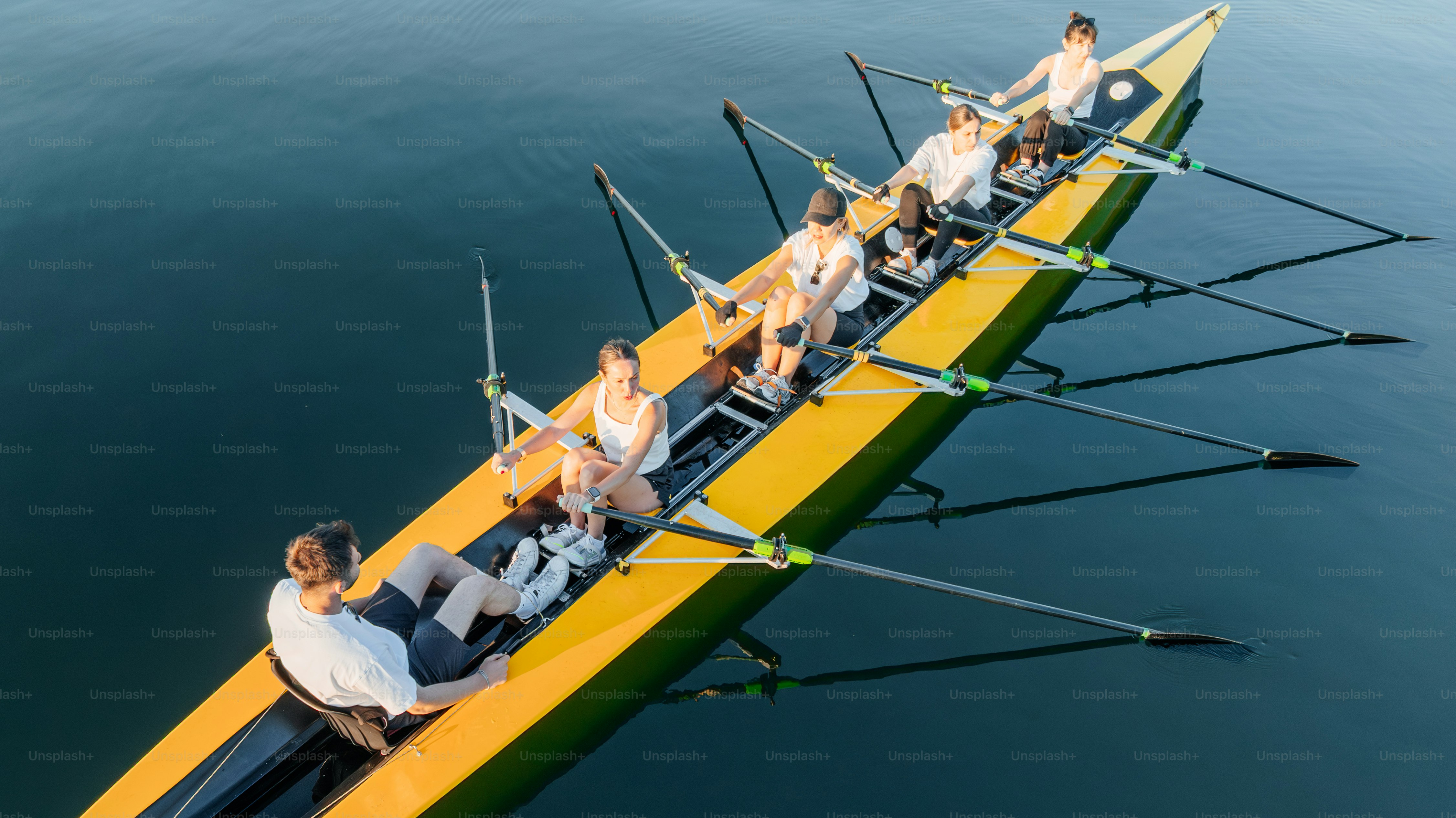 Rowers are working together in a long boat