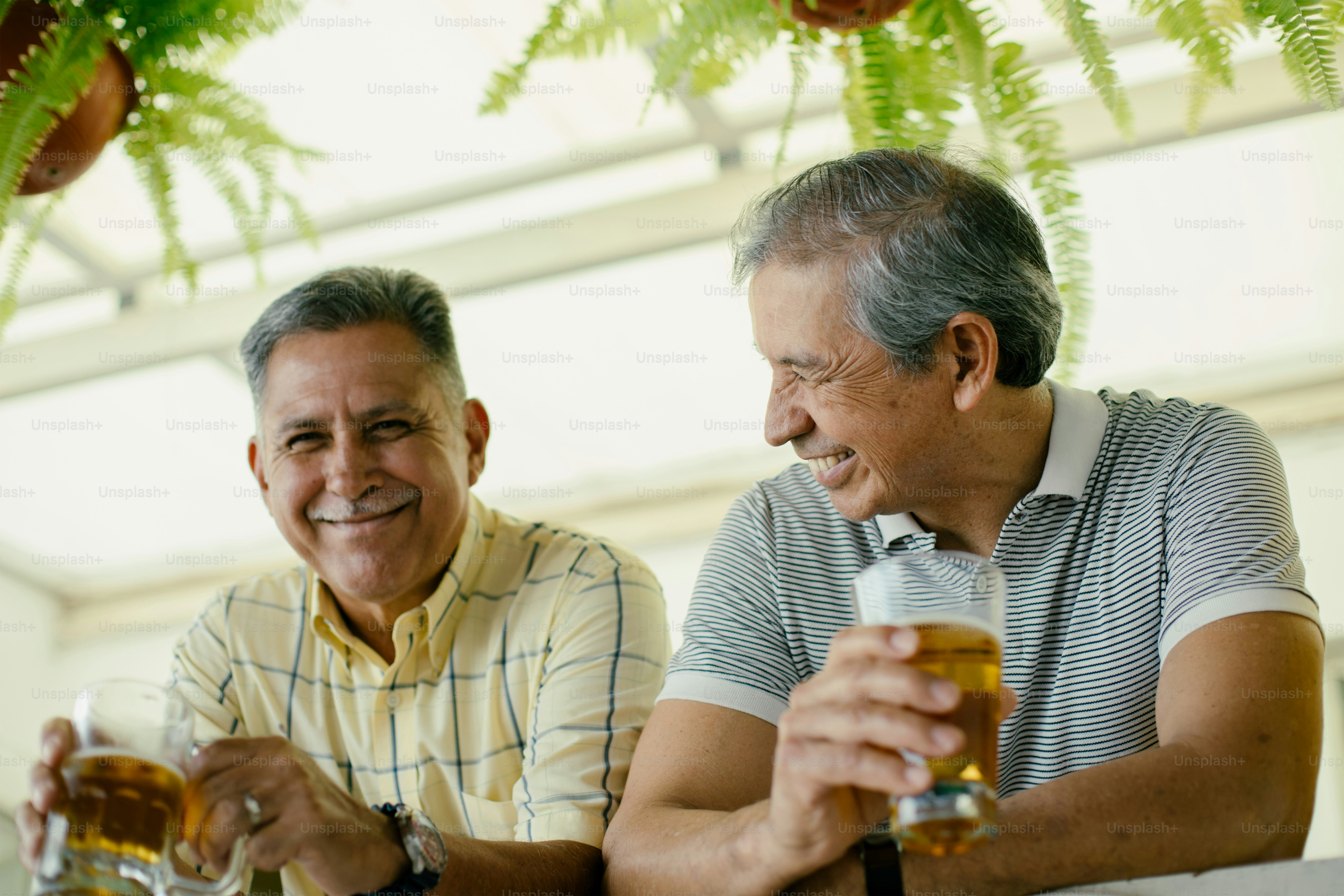 Two older men enjoy beers and a friendly chat.