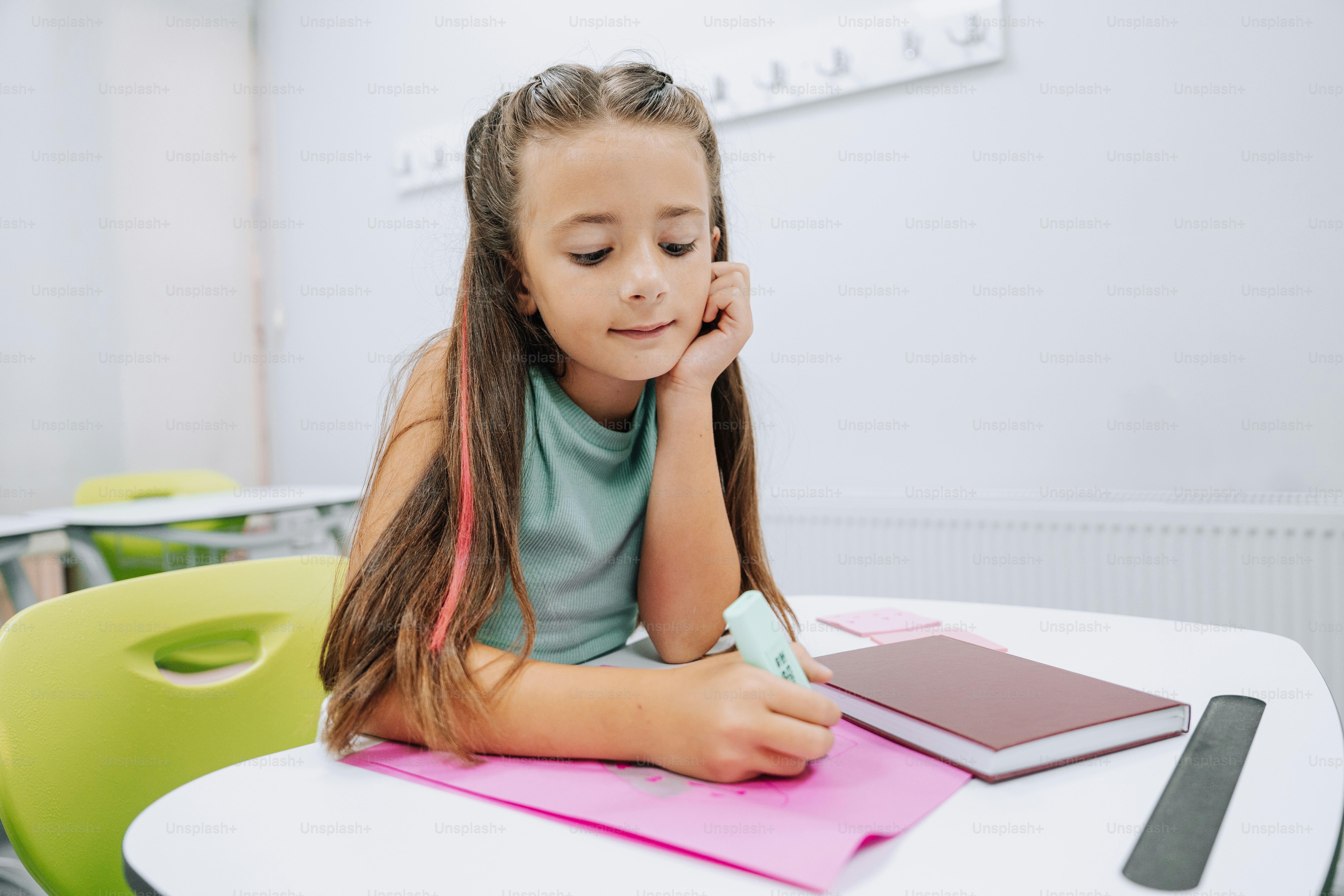 A girl writes at her desk in the classroom.