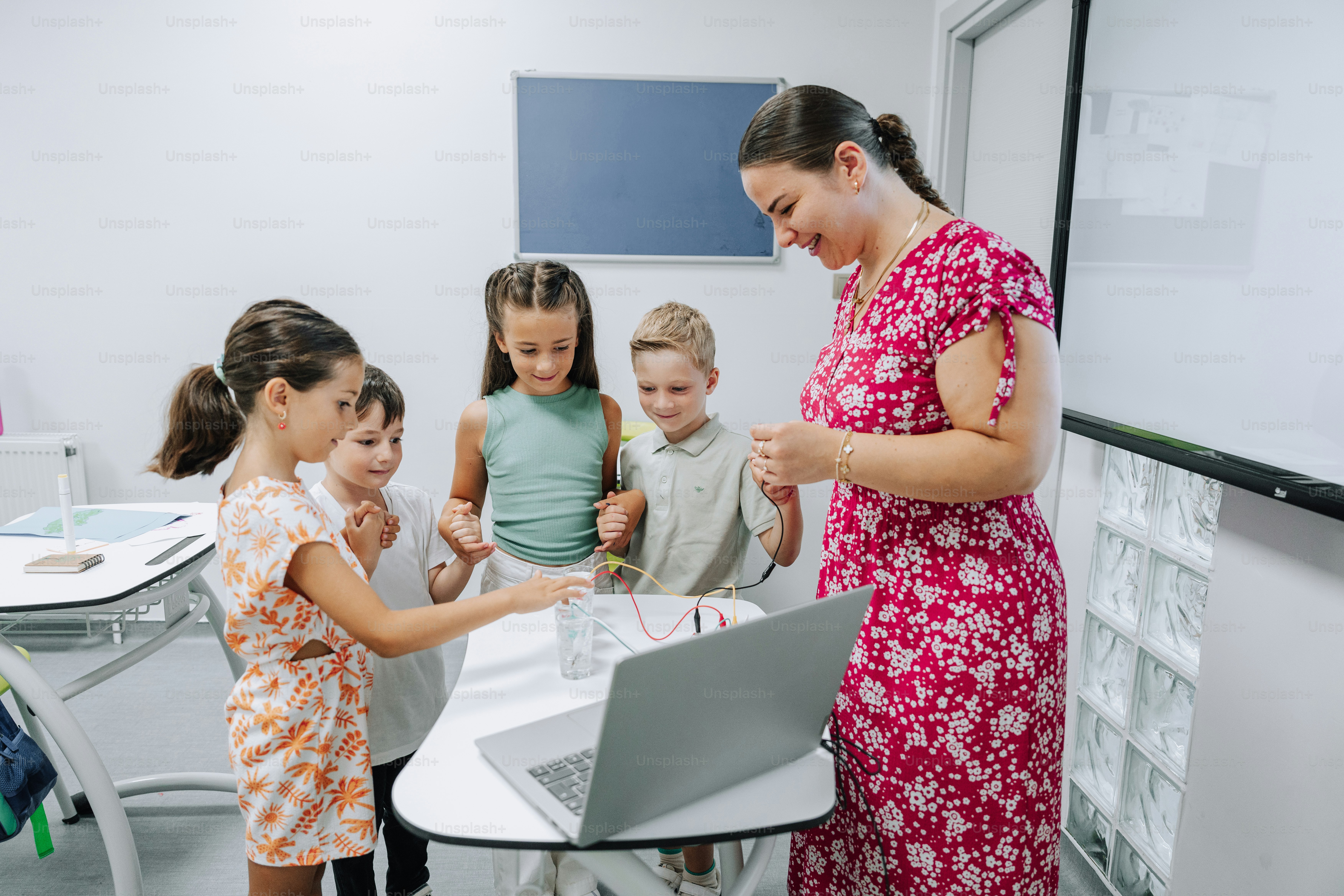 Teacher helps children with a science experiment.