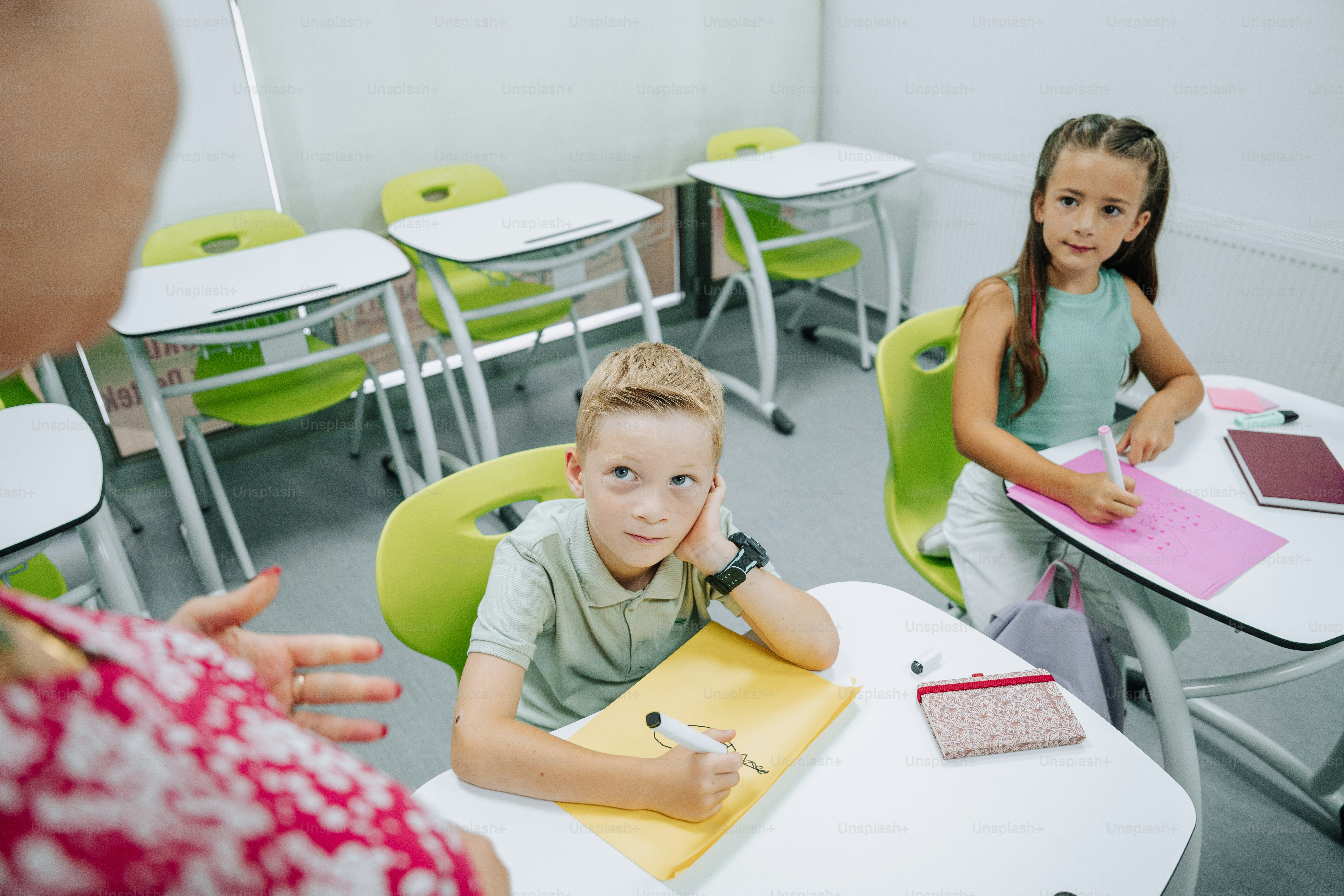 Students look at a teacher in a brightly lit classroom. photo ...