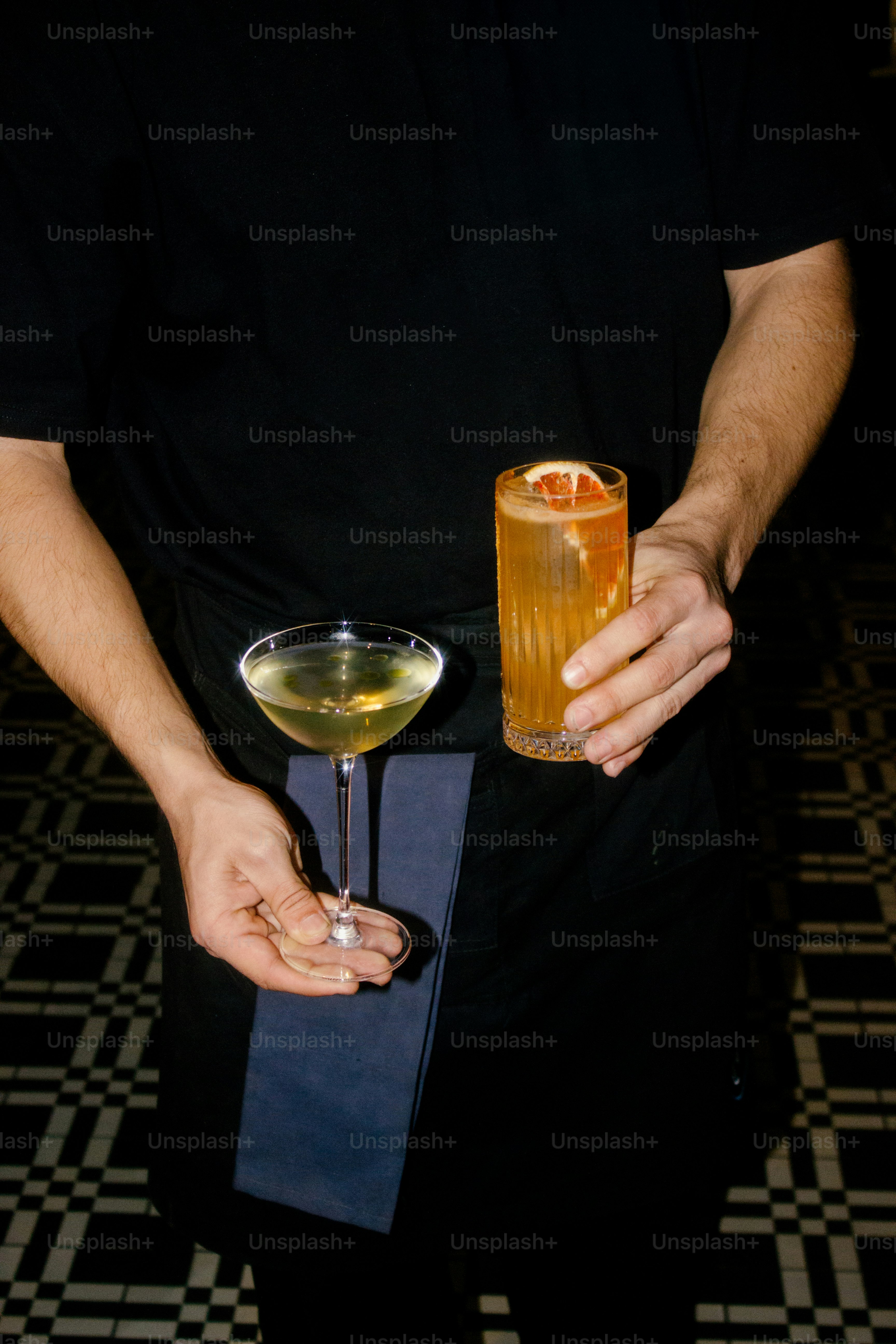 Bartender memegang dua koktail elegan.