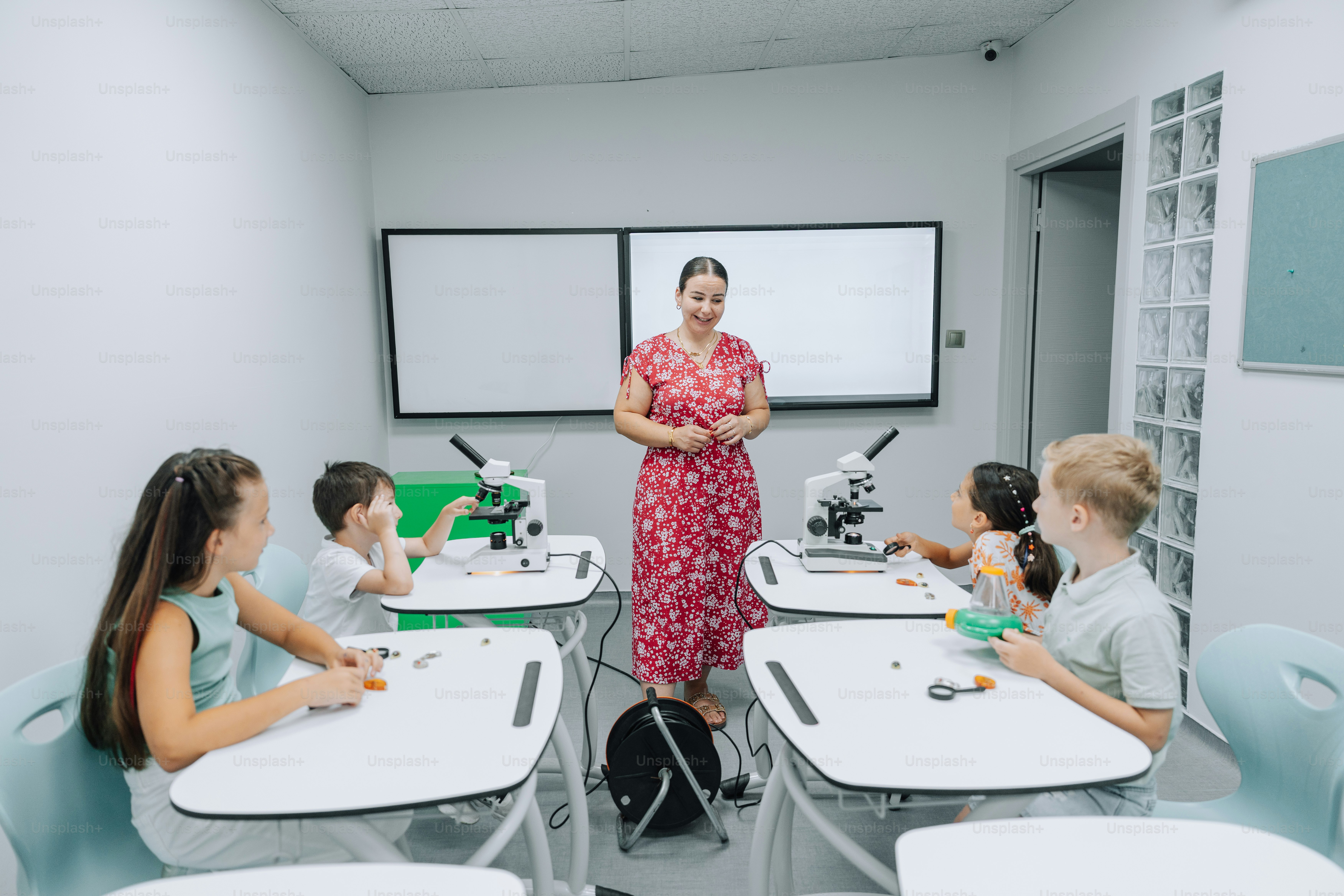 Teacher and students learn in a bright classroom setting.