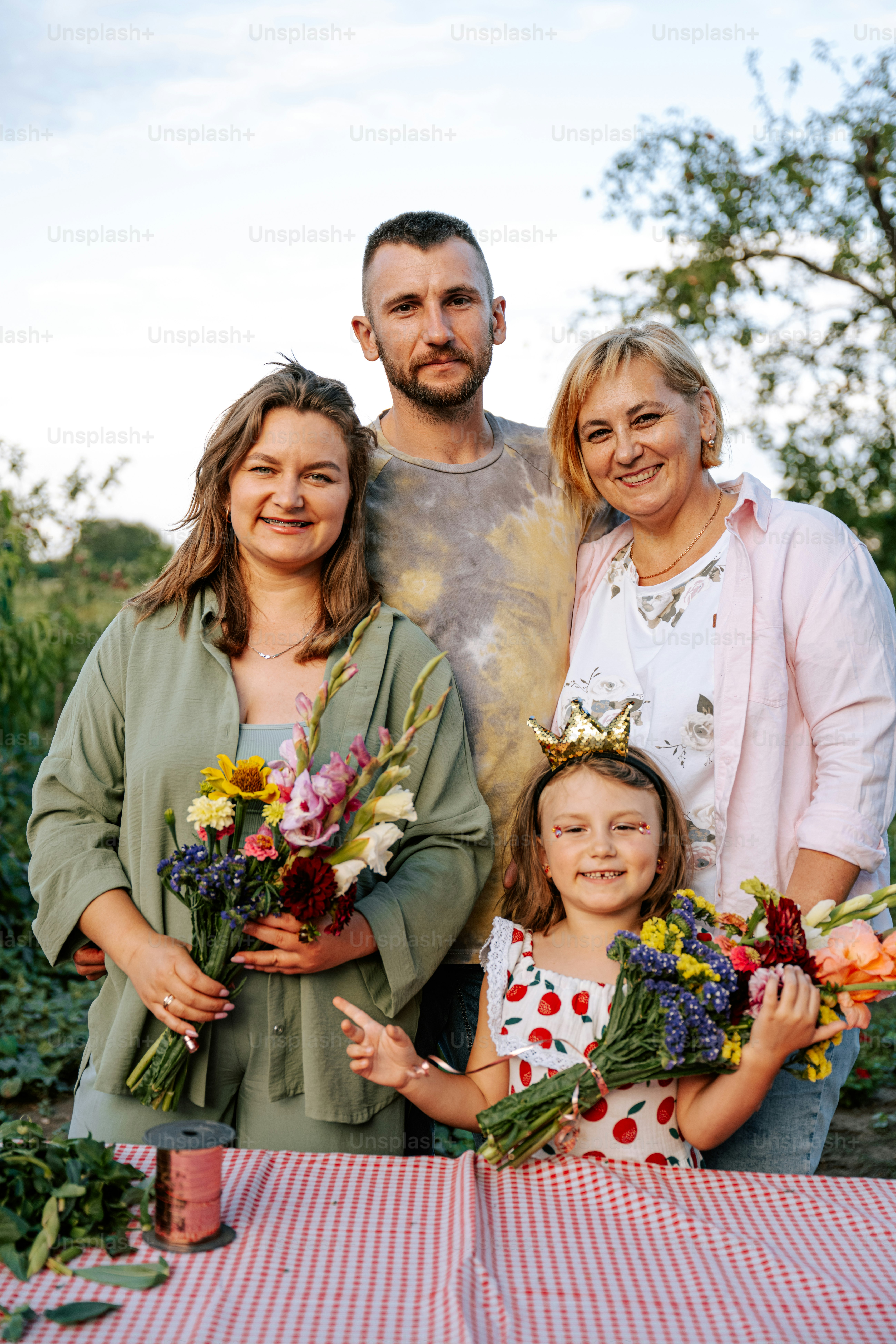A happy family poses with colorful flower bouquets.